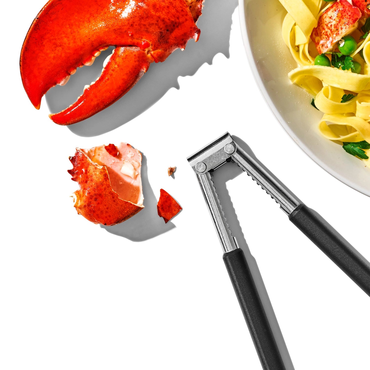 Praktischer Nussknacker von OXO in Grau und Weiß, perfekt für Nüsse und Meeresfrüchte, mit rutschfestem Griff für müheloses Knacken.