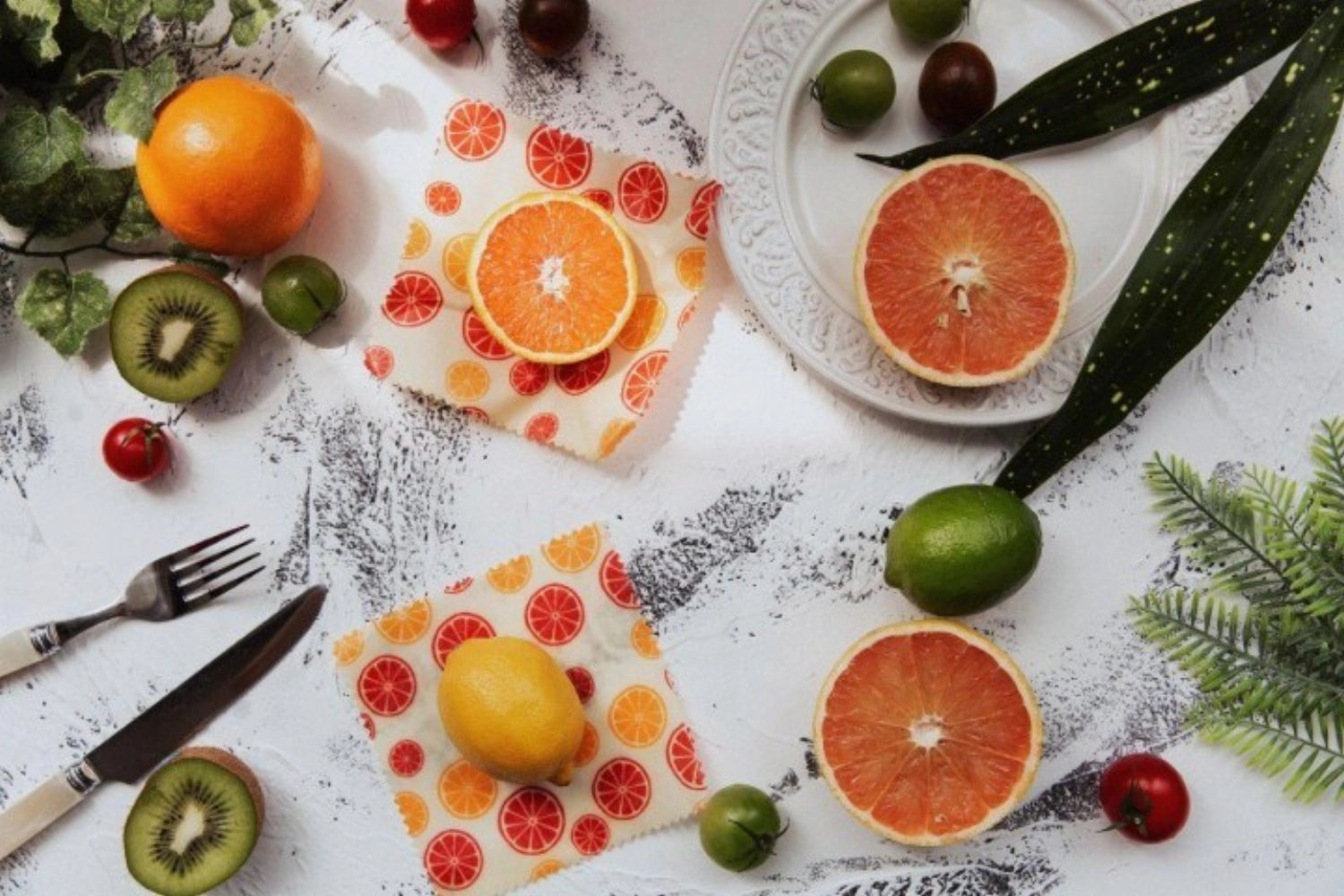 Zwei praktische Bienenwachstücher im frischen Citrus-Muster (16x16 cm) für die umweltbewusste Aufbewahrung von Lebensmitteln.