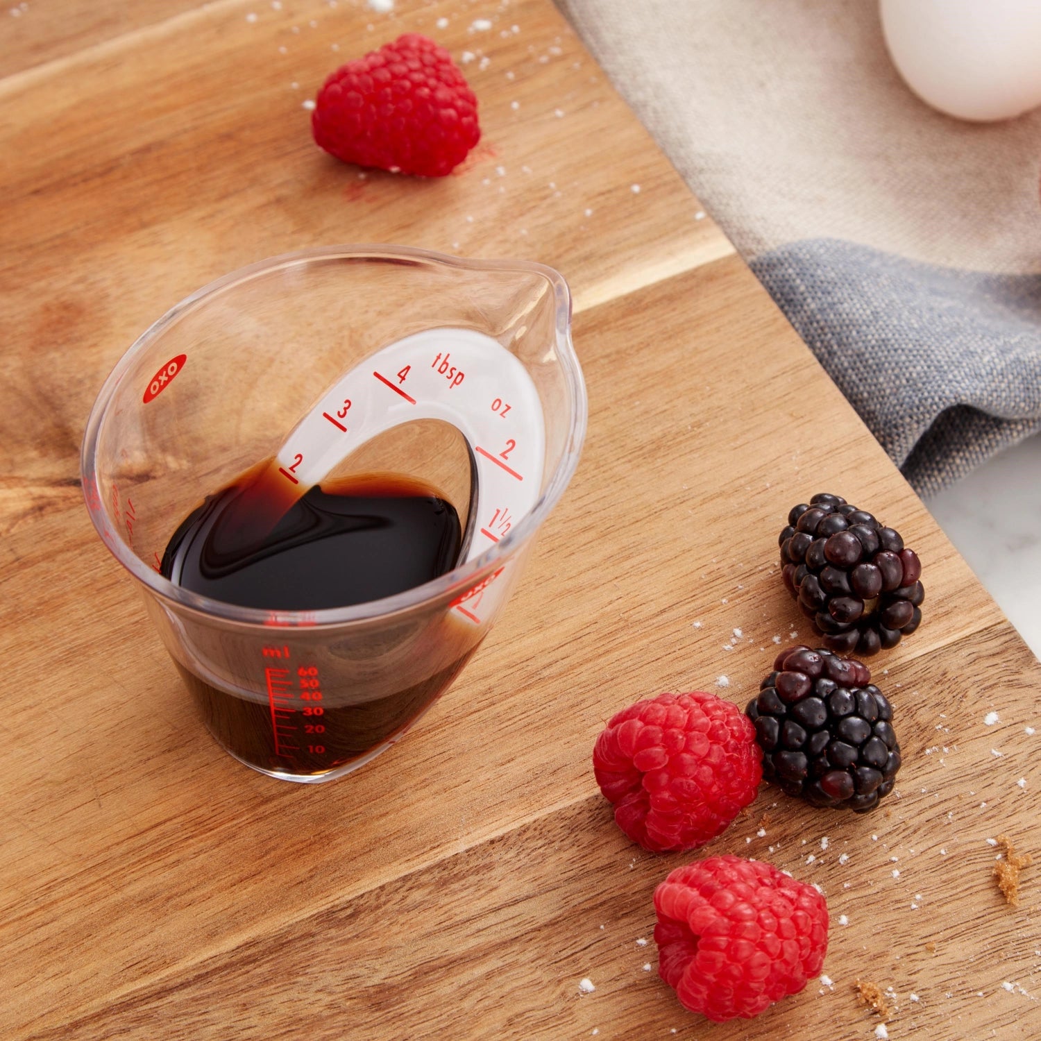 Kleiner, abgewinkelter Messbecher von OXO mit 60 ml Kapazität, perfekt für das exakte Abmessen von Zutaten in der Küche.