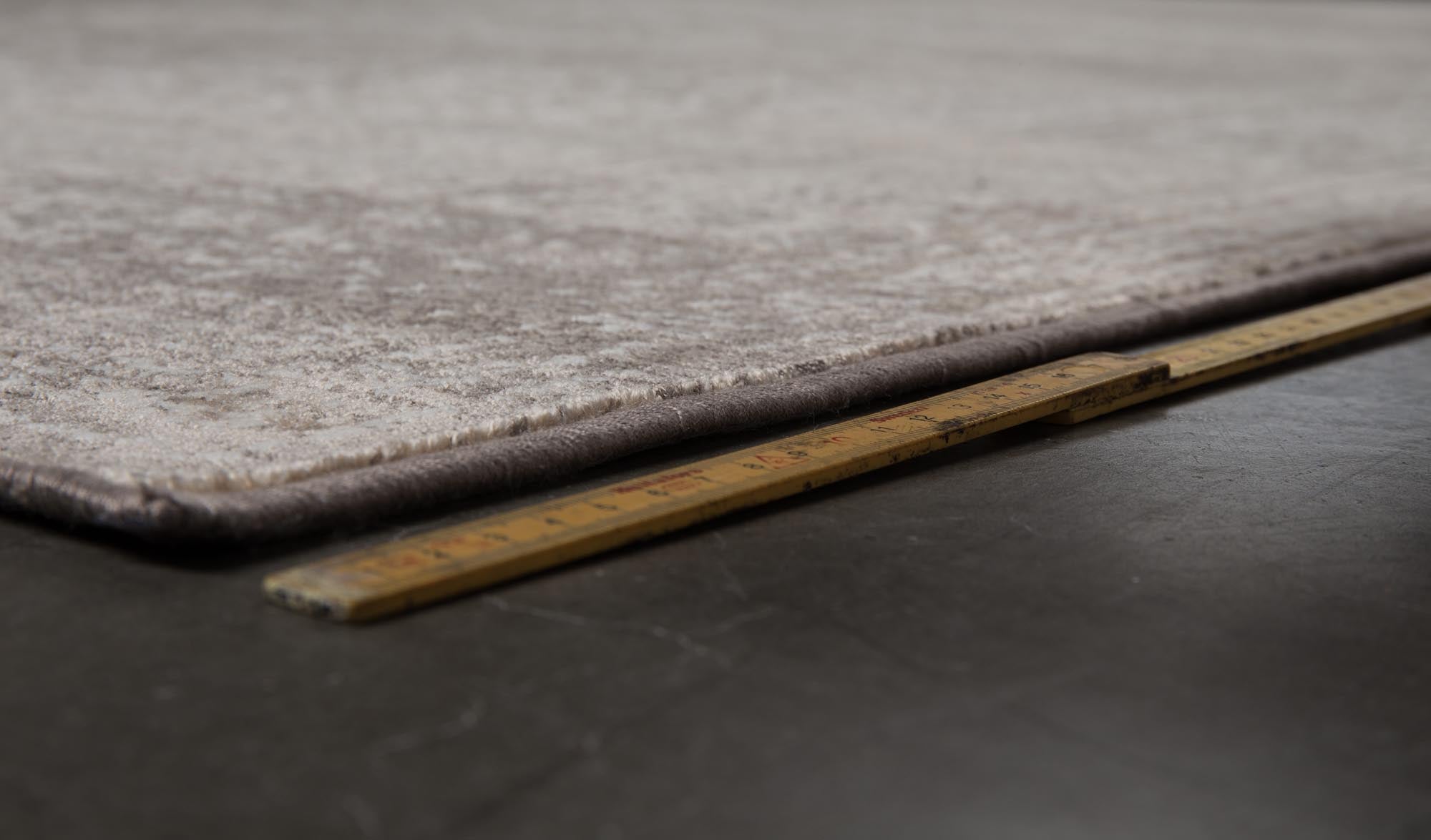 Der Teppich Rugged von Dutchbone zeigt eine einzigartige, strukturierte Oberfläche in warmen Erdtönen, ideal für gemütliche Wohnräume.