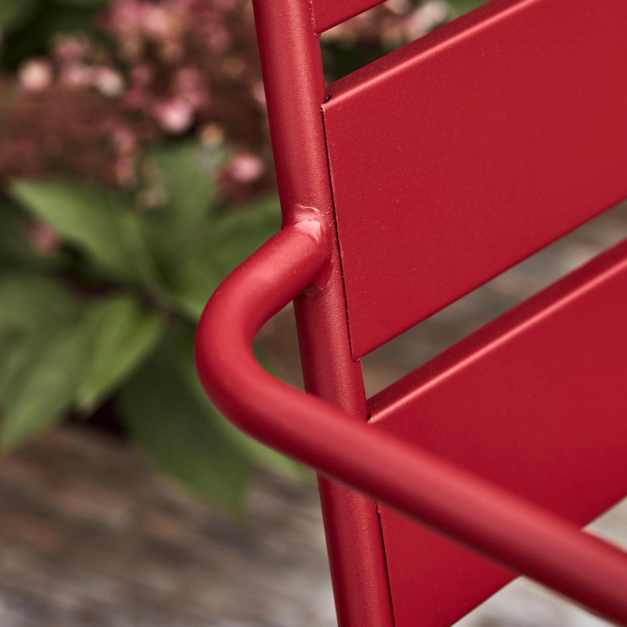 Eleganter roter Lounge-Sessel HDHelo von House Doctor, ideal für entspannte Stunden im Freien, ausgestattet mit komfortablen Armlehnen.