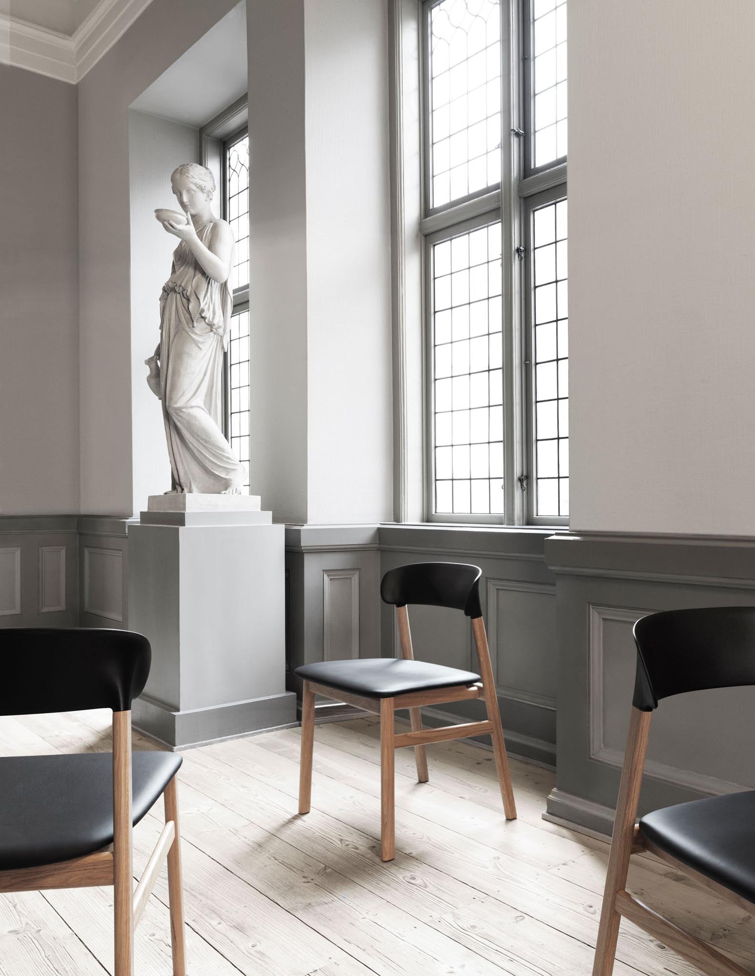 Eleganter Herit Stuhl mit Armlehnen von Normann Copenhagen, der stilvolles skandinavisches Design und hohen Sitzkomfort vereint.