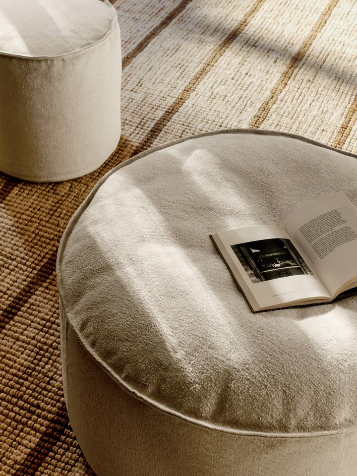 Entdecken Sie den Aun Cotton Pouf Ø80 von Ferm Living – ein stilvolles, nachhaltiges Möbelstück aus Bio-Baumwolle, das Komfort und Eleganz vereint.