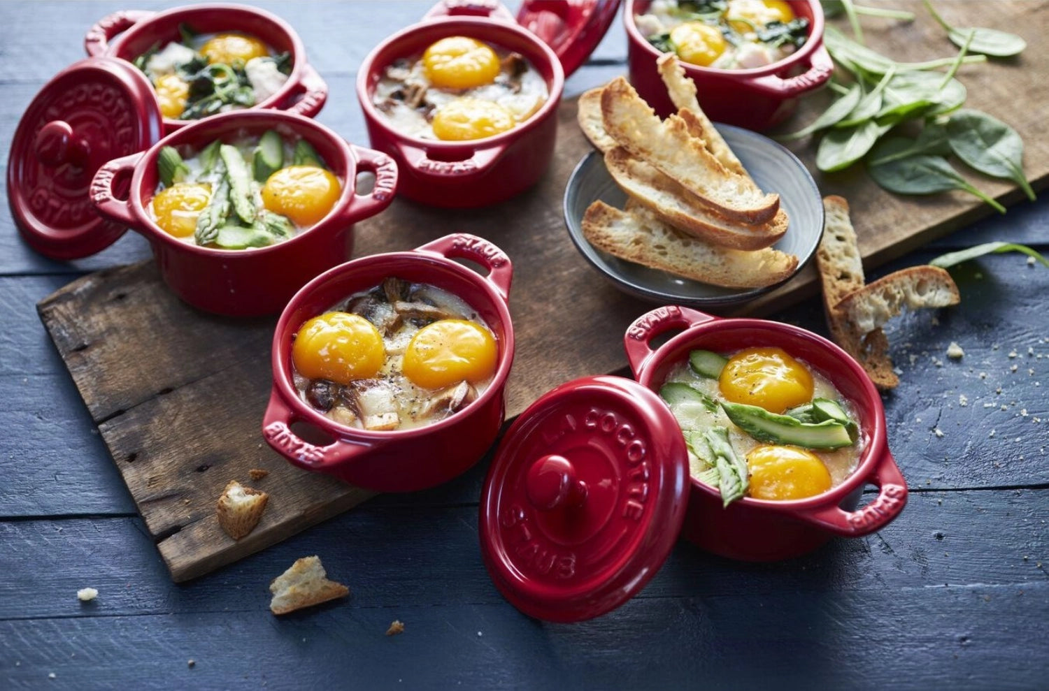 Set aus vier kleinen, runden Cocottes in leuchtendem Kirschrot, perfekt für kreative Portionen und ansprechende Tischpräsentation.