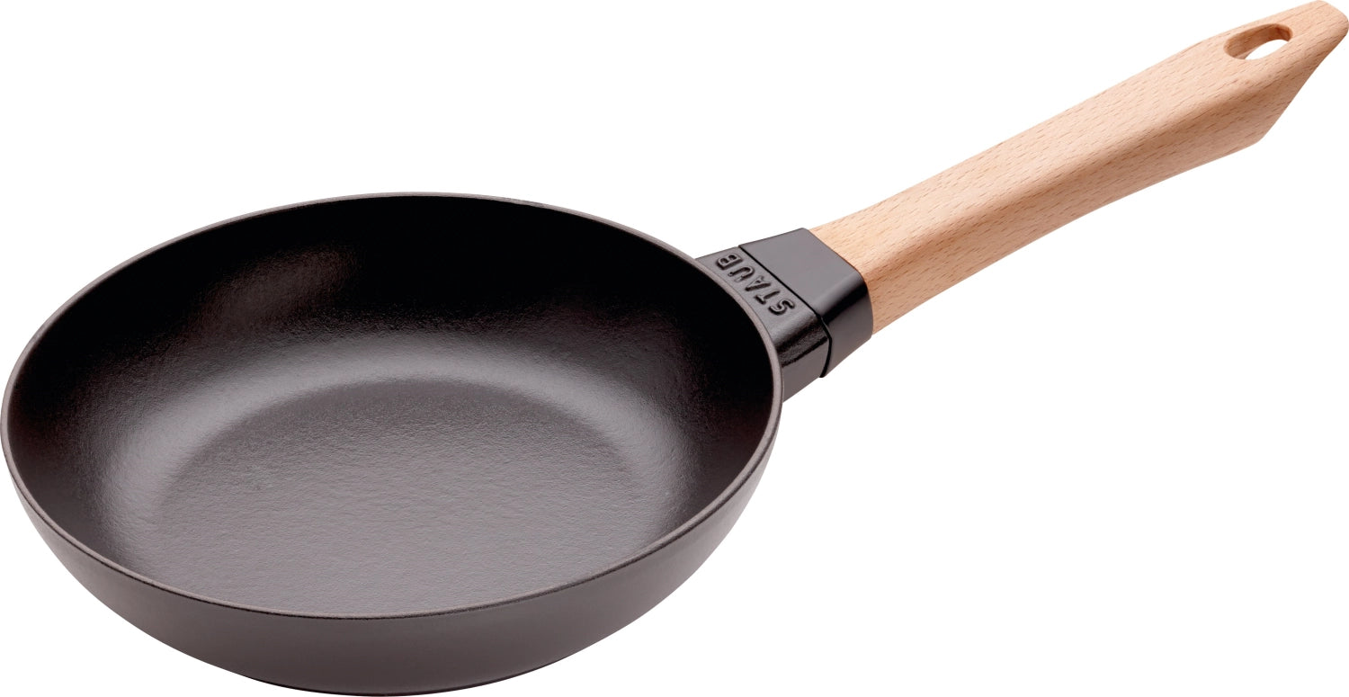 Schwarze Gusseisen-Bratpfanne mit 20 cm Durchmesser und stilvollem Holzgriff, ideal für schmackhafte Bratgerichte und gleichmäßige Wärmeverteilung.