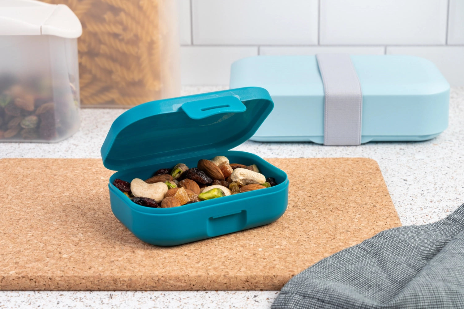 Kleine, praktische Snackbox in tiefem Meeresgrün von AMUSE BASIC, ideal für Snacks unterwegs. Maße: 109x80x37 mm.