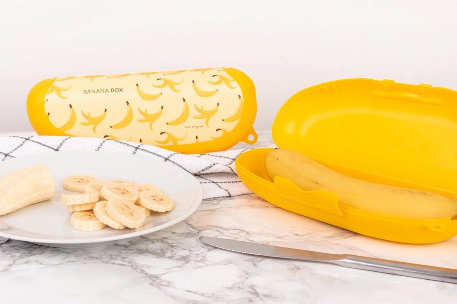 Bananenbox in leuchtendem Gelb, ideal für die Aufbewahrung von Bananen und Snacks. Praktische Größe von 223x90x50 mm für unterwegs.