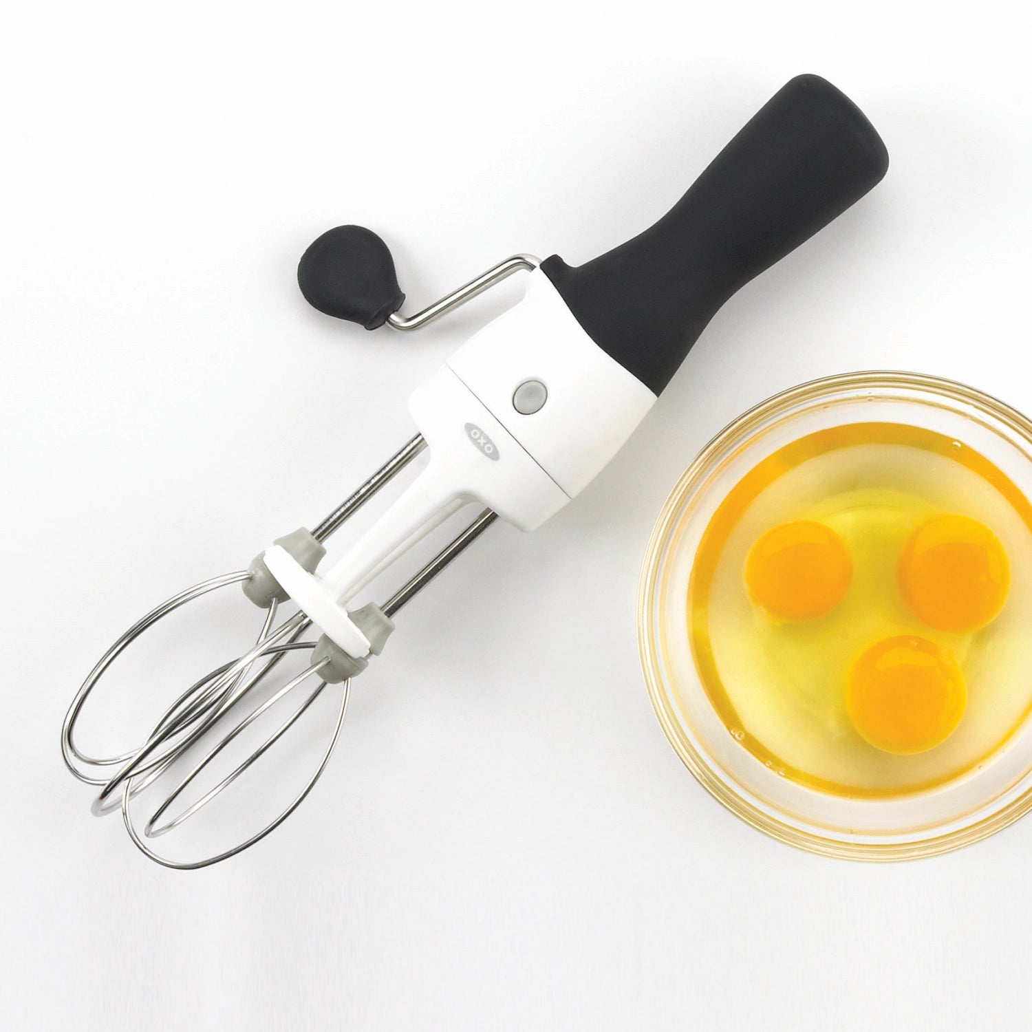 Eleganter weißer Handrührer von OXO, perfekt zum schnellen und mühelosen Vermengen von Teigen und Zutaten, mit ergonomischem Design für besten Komfort.