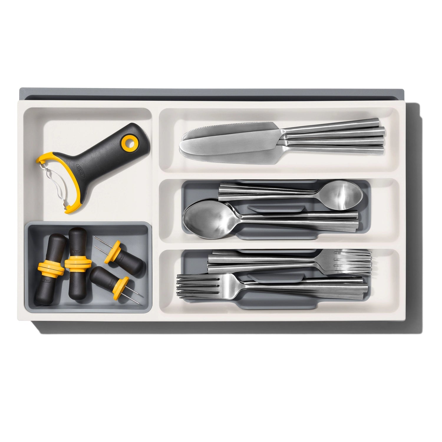 Erweiterbare Schubladeneinlage von OXO Good Grips, ideal zur flexiblen Organisation von Besteck und Küchenutensilien in Schubladen.