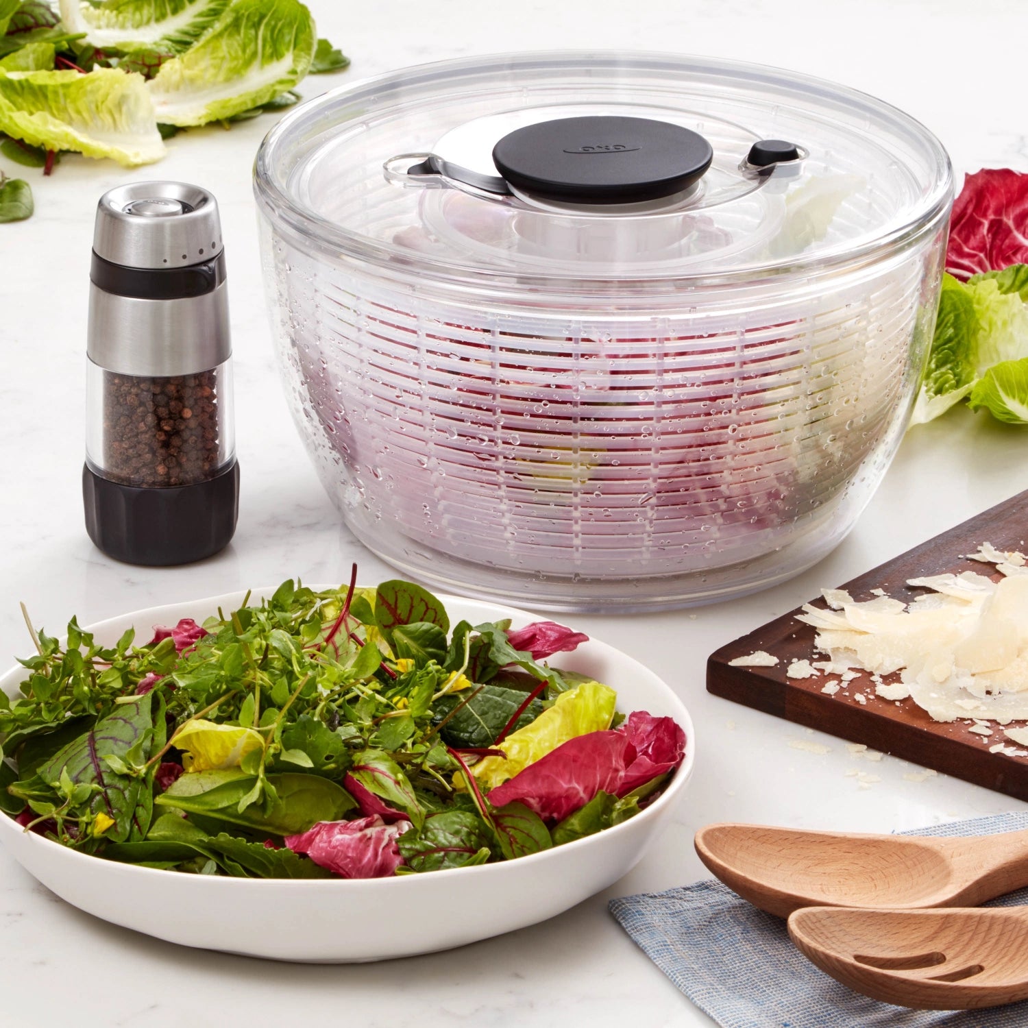 Transparente, runde Salatschleuder von OXO mit 5,8 l Volumen und 26,7 cm Durchmesser, ideal für frische Salate und Gemüse.