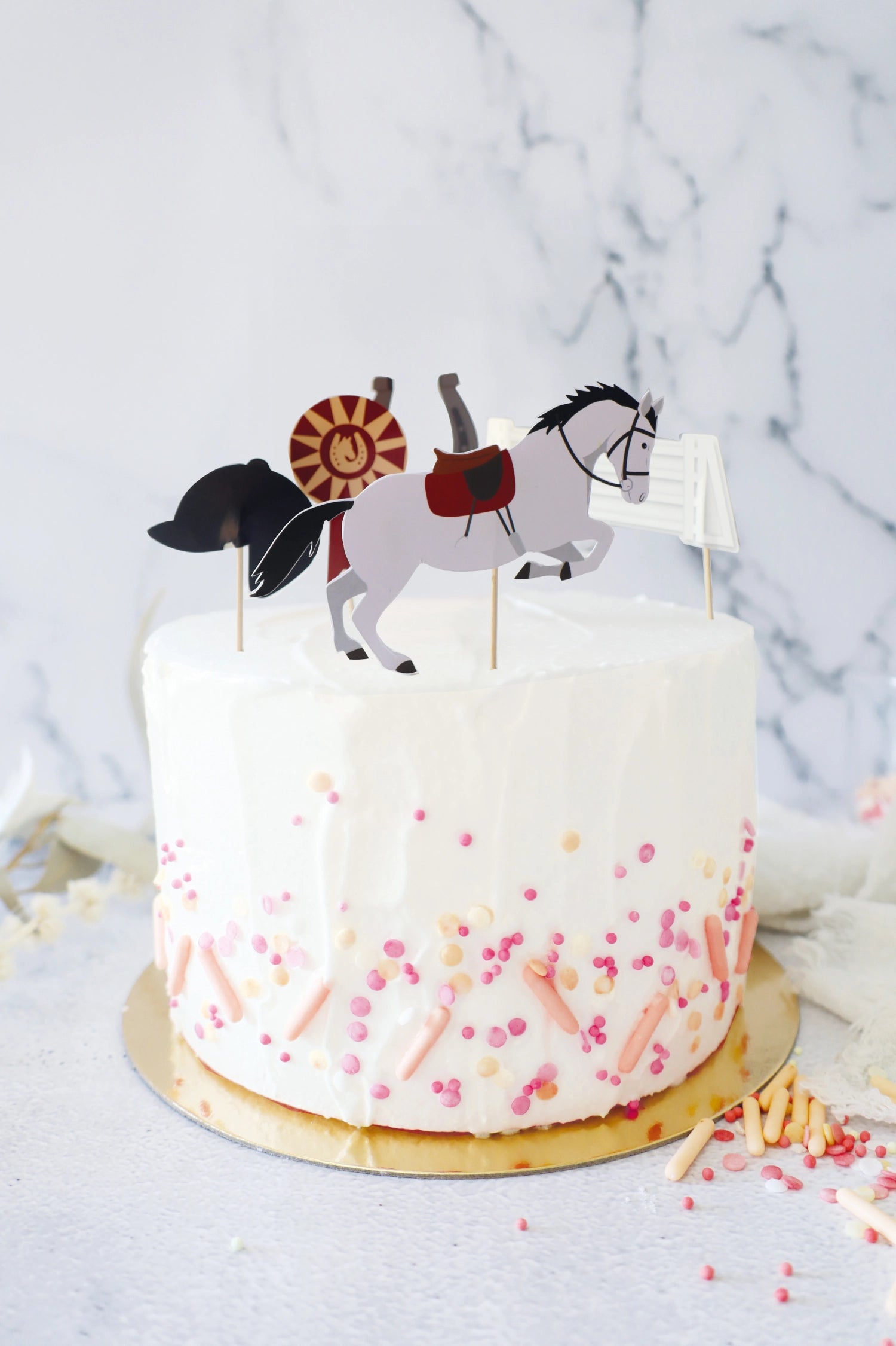 Fünf kreative Kuchendekorationen mit Reitmotiven aus Papier, ideal für Pferdeliebhaber und besondere Feierlichkeiten.
