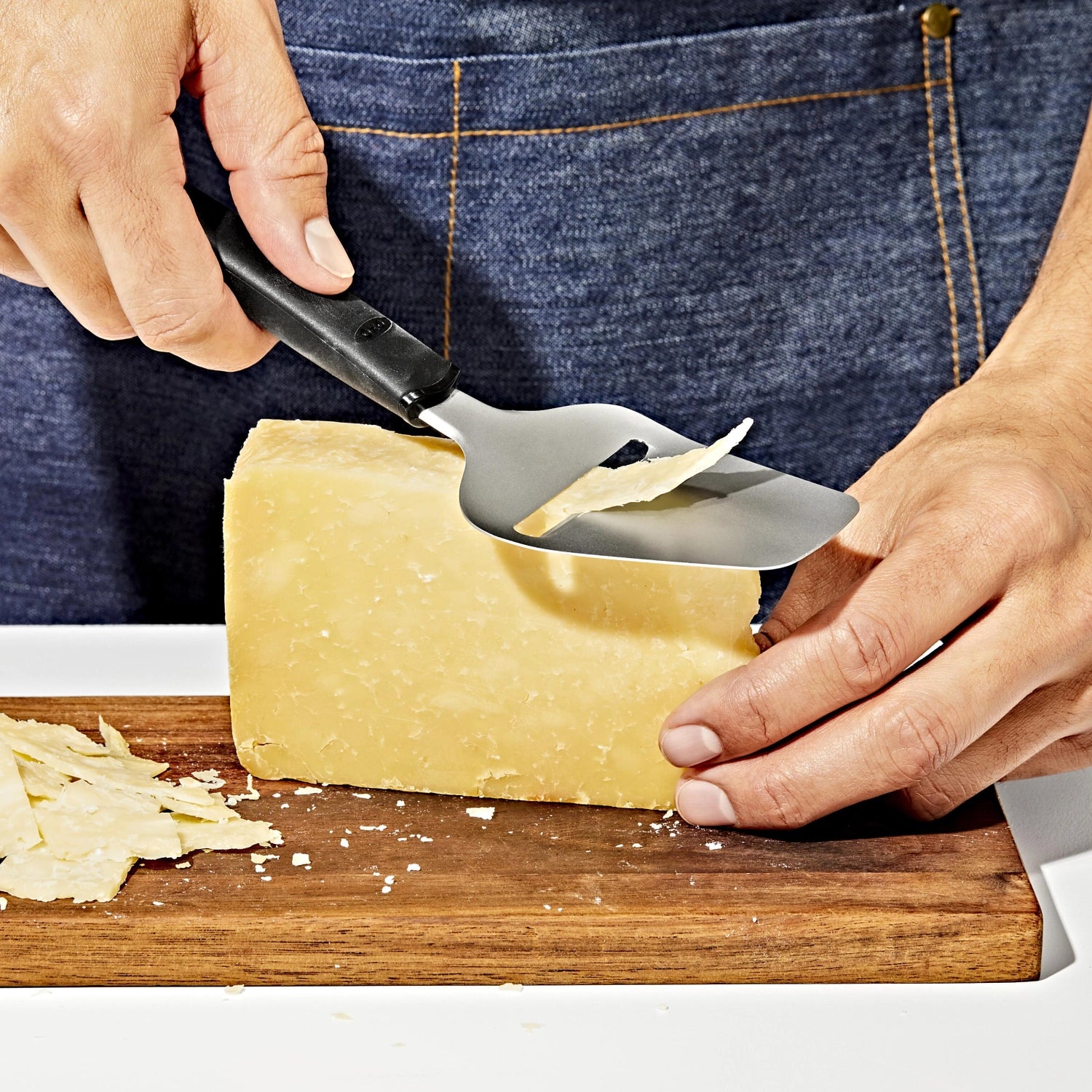 Good Grips Käseschneider von OXO mit Antihaftbeschichtung, ideal zum mühelosen Schneiden von Käse, ergonomisches Design für komfortable Handhabung.