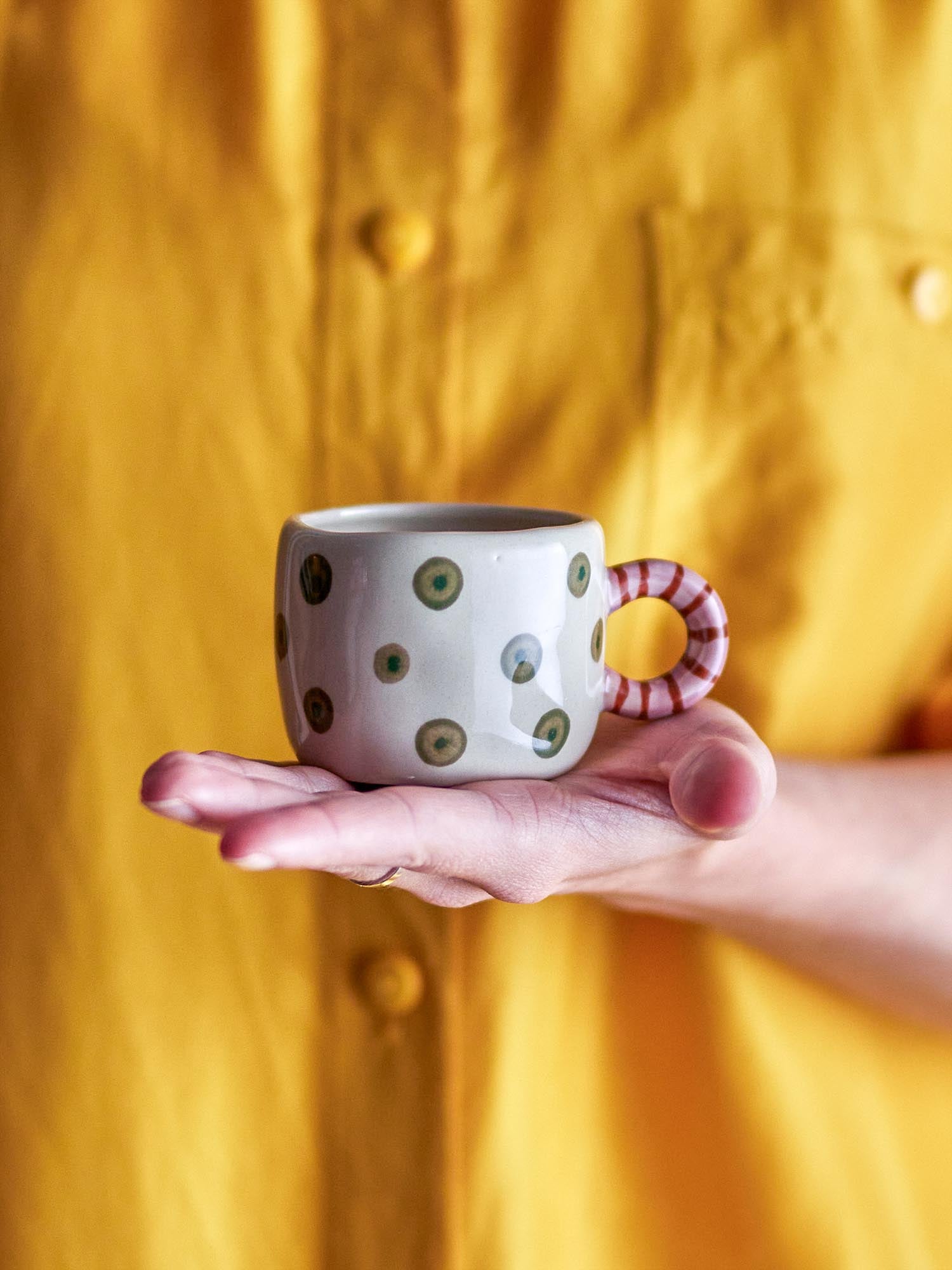Die Nini Tasse von Bloomingville: Ein handbemaltes Steingut-Kunstwerk in Grün mit verspieltem Henkel, ideal für heisse Getränke.