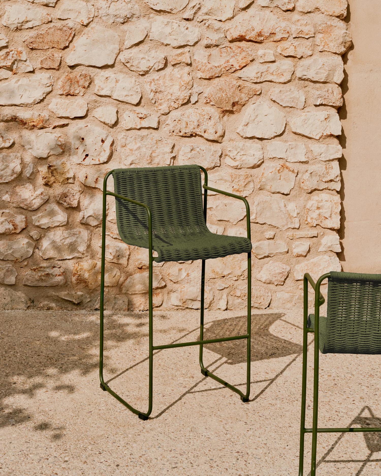 Der Hocker Maurina vereint robusten, grünen Stahl mit elegantem Seil für stilvolle Outdoor-Entspannung.