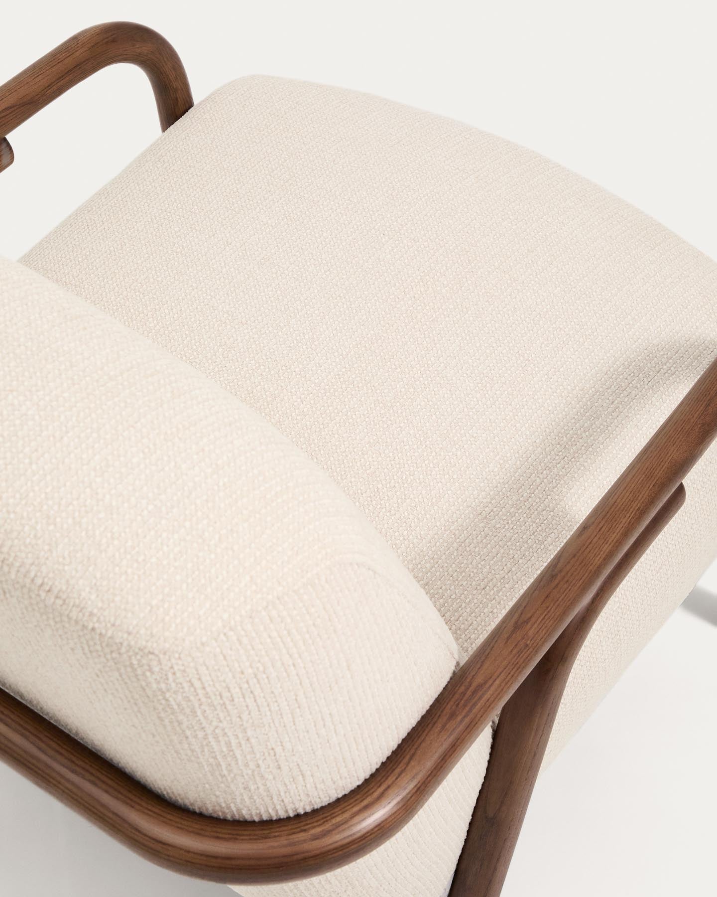 Eleganter Sessel Sylo aus weichem Chenille in Beige, gestützt von stabilen Eschenholzbeinen mit edlem Nussbaum-Finish.