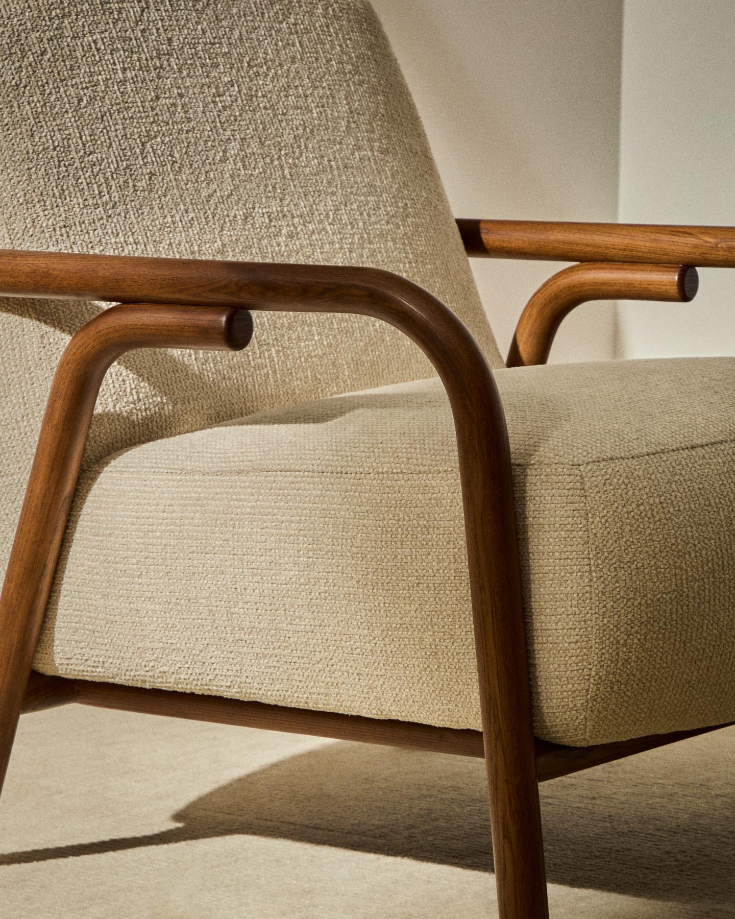 Eleganter Sessel Sylo in beigem Chenille, ausgestattet mit stabilen Eschenholzbeinen und einem stilvollen Nussbaum-Finish, ideal für jedes Zuhause.