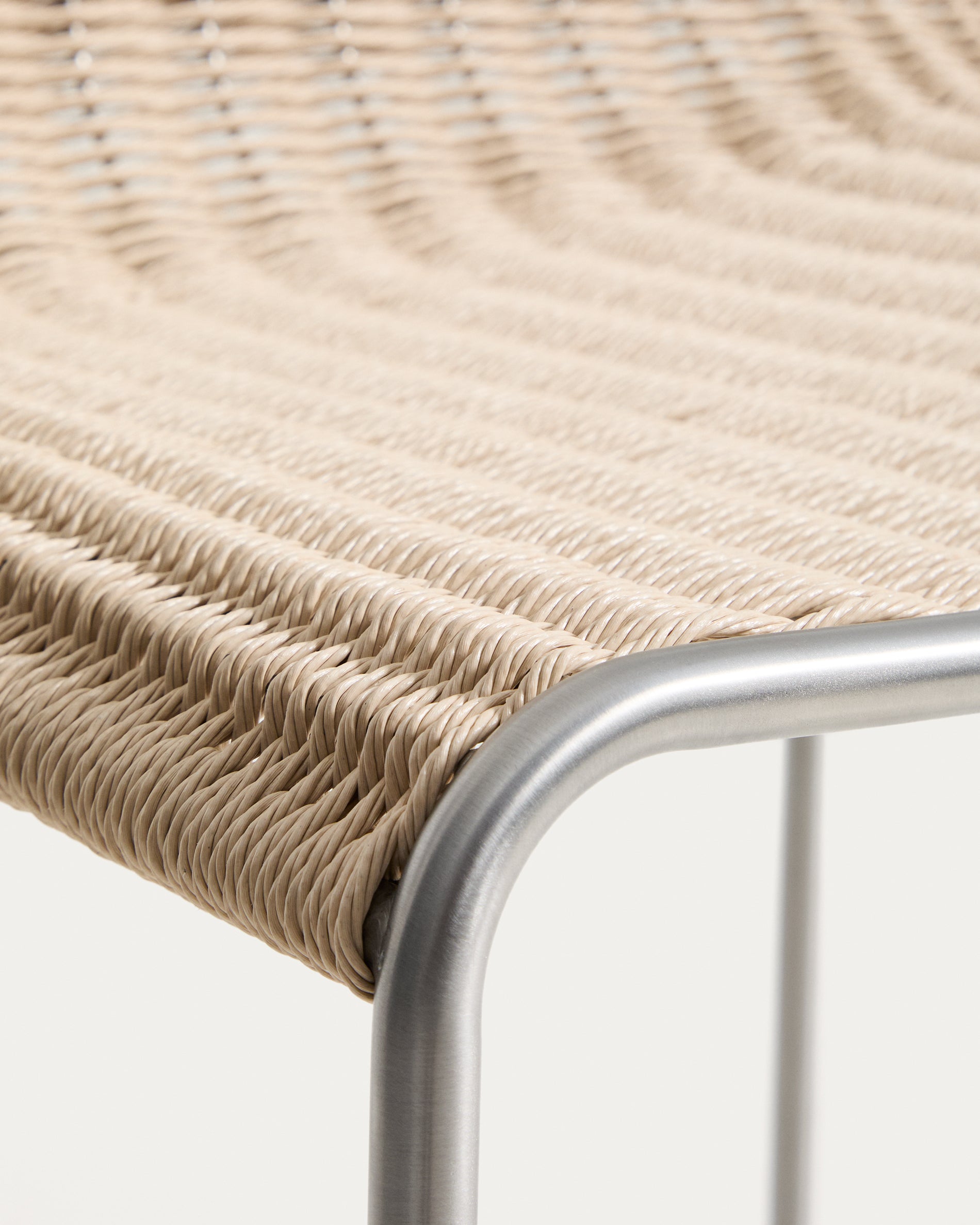 Moderner Stapelhocker Tavari in sanftem Beige, aus robustem Synthetikseil und gebürstetem Edelstahl, ideal für stilvolle Outdoor-Bereiche.
