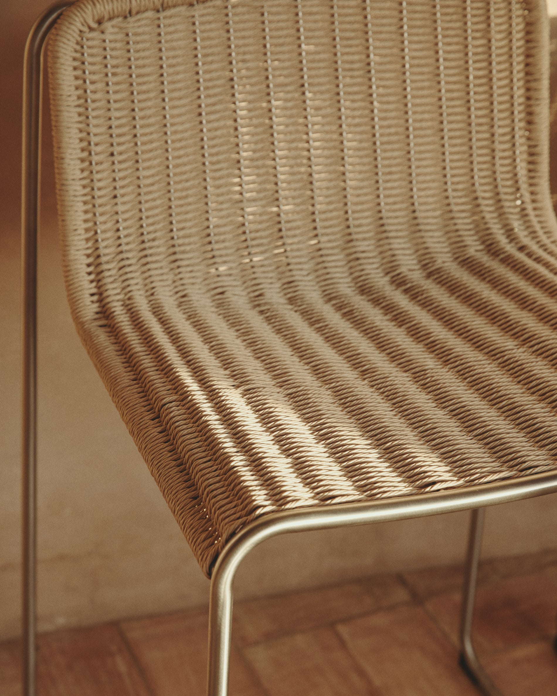 Eleganter Stapelhocker Tavari in Beige, gefertigt aus strapazierfähigem Synthetikseil und gebürstetem Edelstahl, perfekt für den Außenbereich.