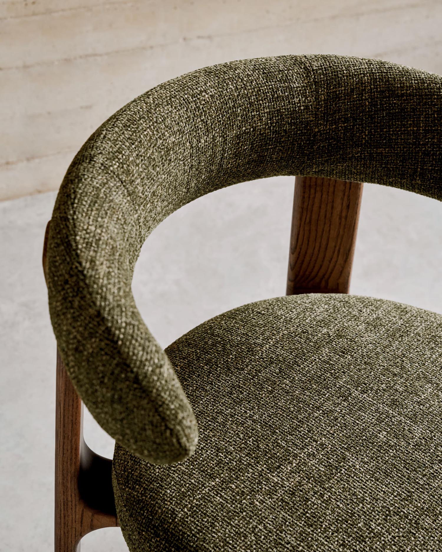 Eleganter Stuhl aus grüner Chenille und FSC-zertifiziertem Eschenholz mit Walnuss-Finish, vereint Stil und Nachhaltigkeit.