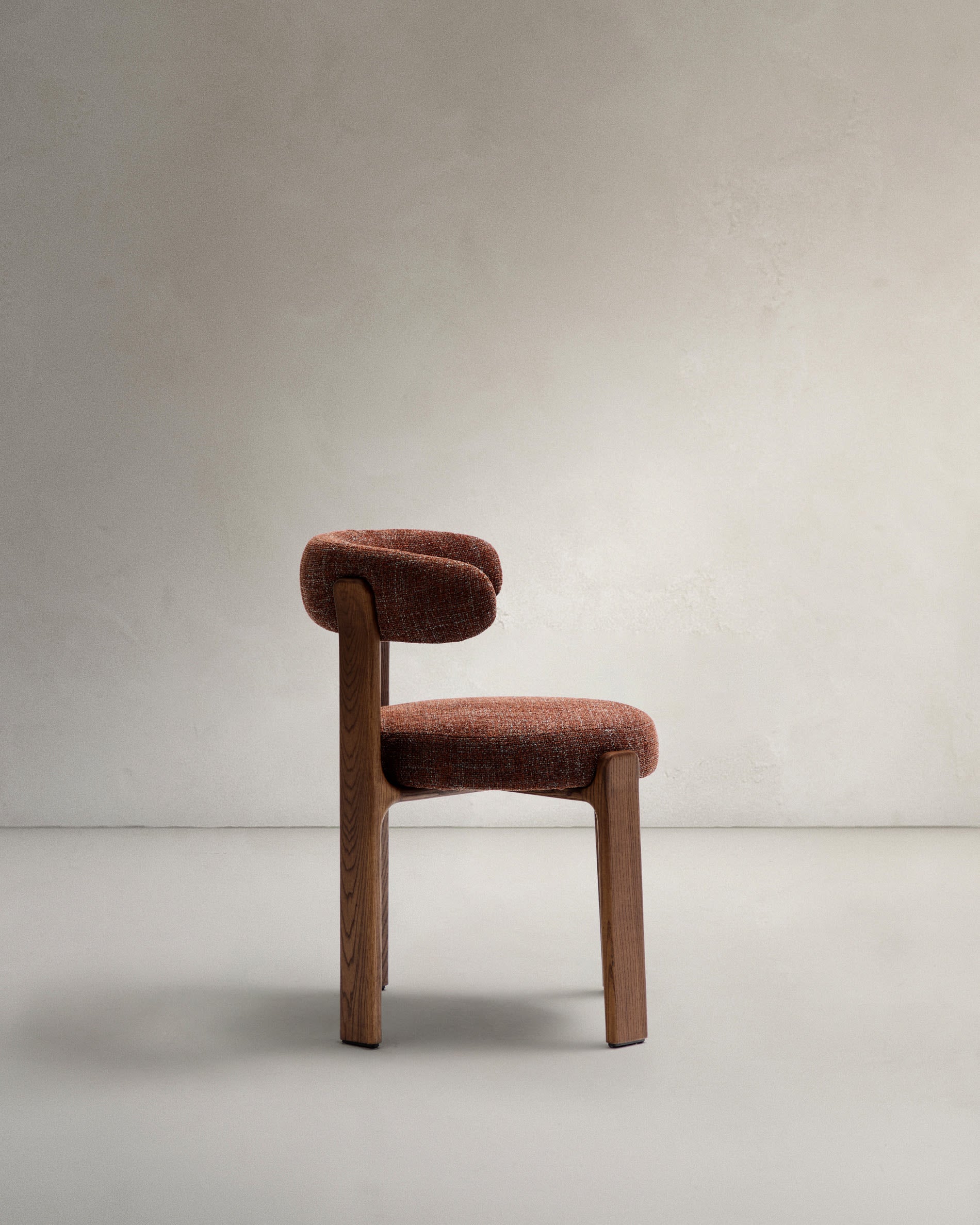 Stylischer Stuhl aus brauner Chenille und robustem Eschenholz mit edlem Walnuss-Finish, ideal für zeitgemäße Wohnräume.