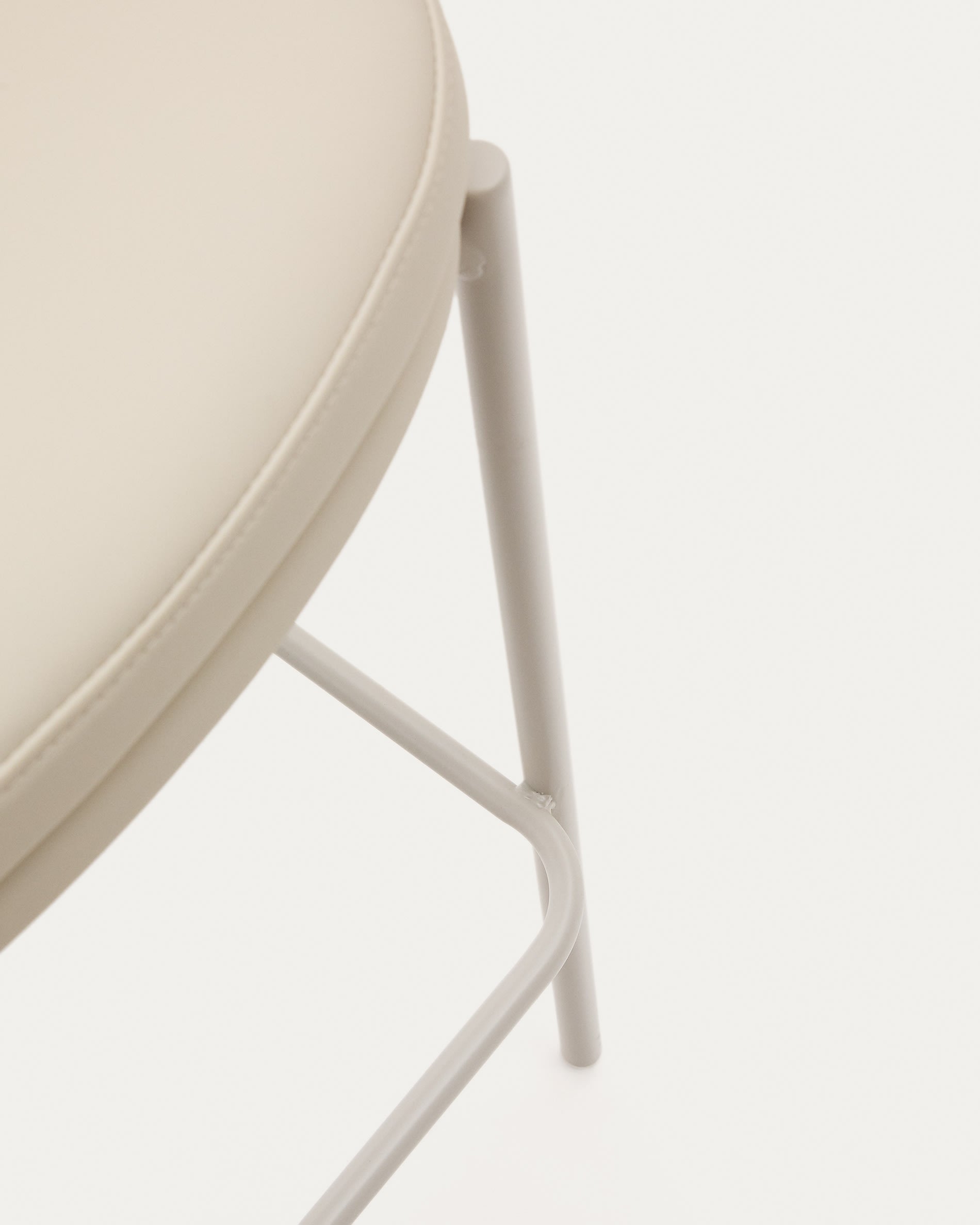 Eamy Hocker von Kave Home: Eleganter Hocker aus beigem Kunstleder, stabiler Esche und modernen Metall-Details – perfekt für stilvolle Akzente in deinem Zuhause.