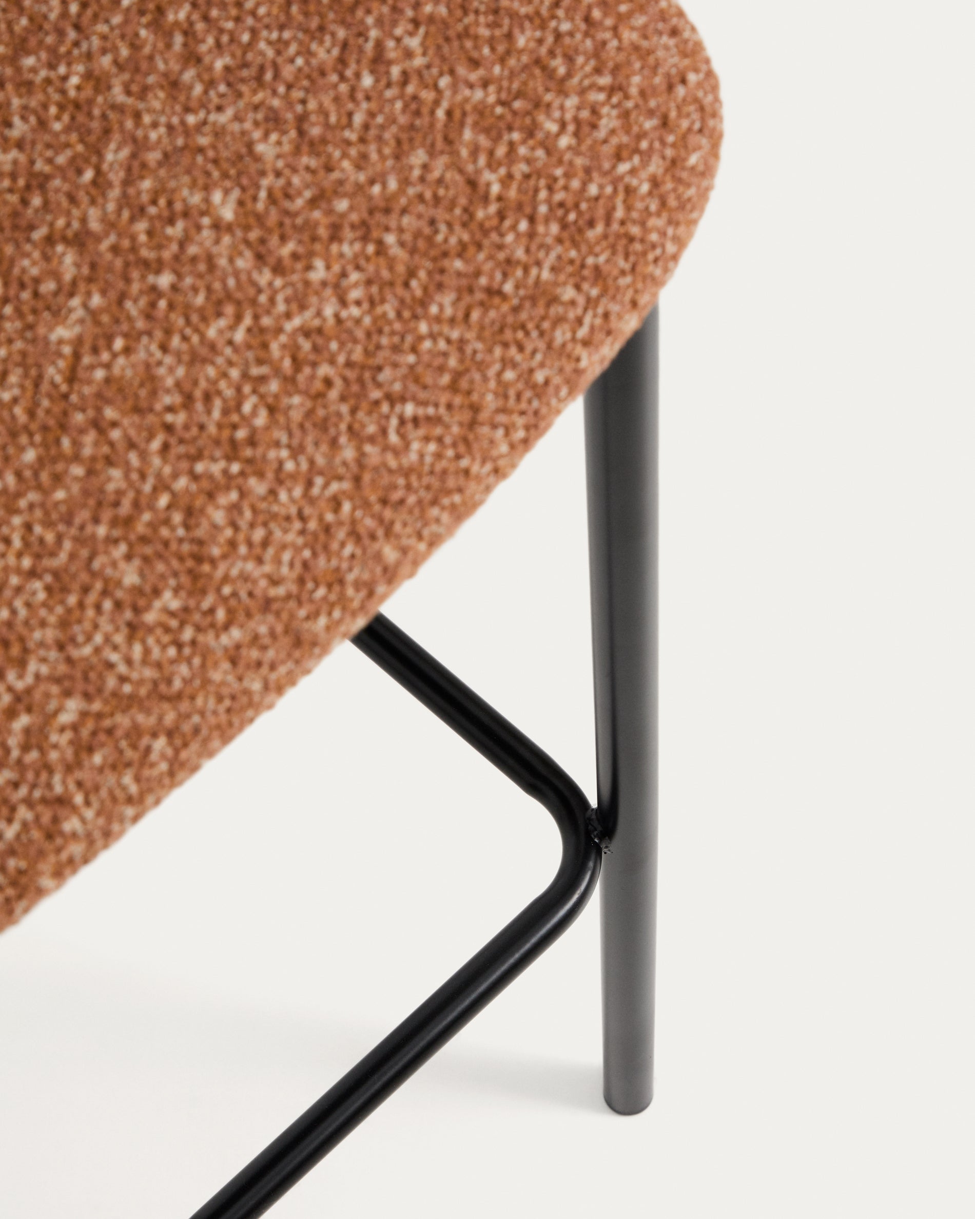 Moderner Hocker Ciselia in kräftigem Terrakotta-Chenille, kombiniert mit robusten Stahlbeinen in Schwarz – ideal für trendige Wohnräume.