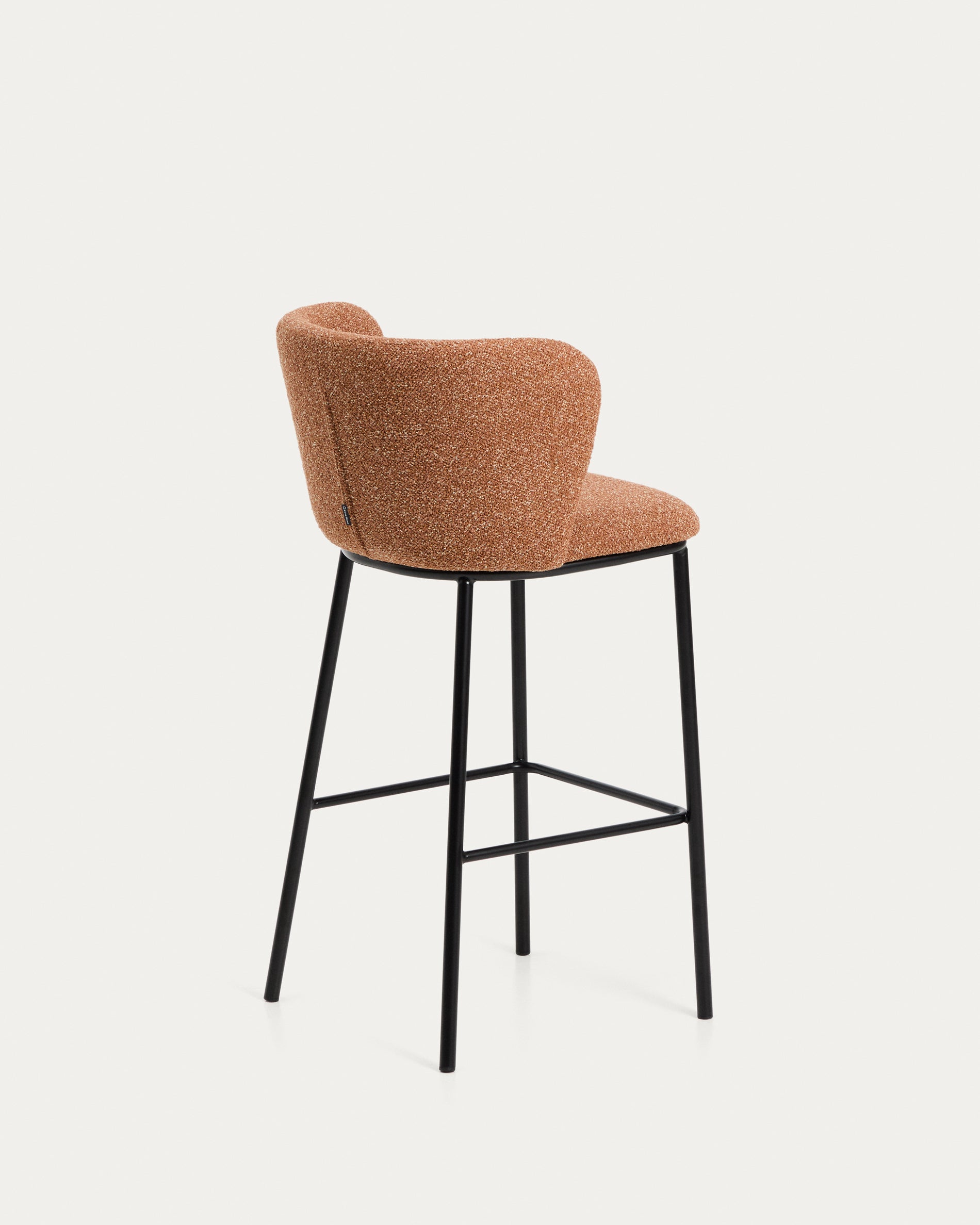 Moderner Hocker Ciselia aus weichem, terrakottafarbenem Chenille mit stabilen, schwarz lackierten Stahlbeinen – perfekt für gemütliche Sitzgelegenheiten.