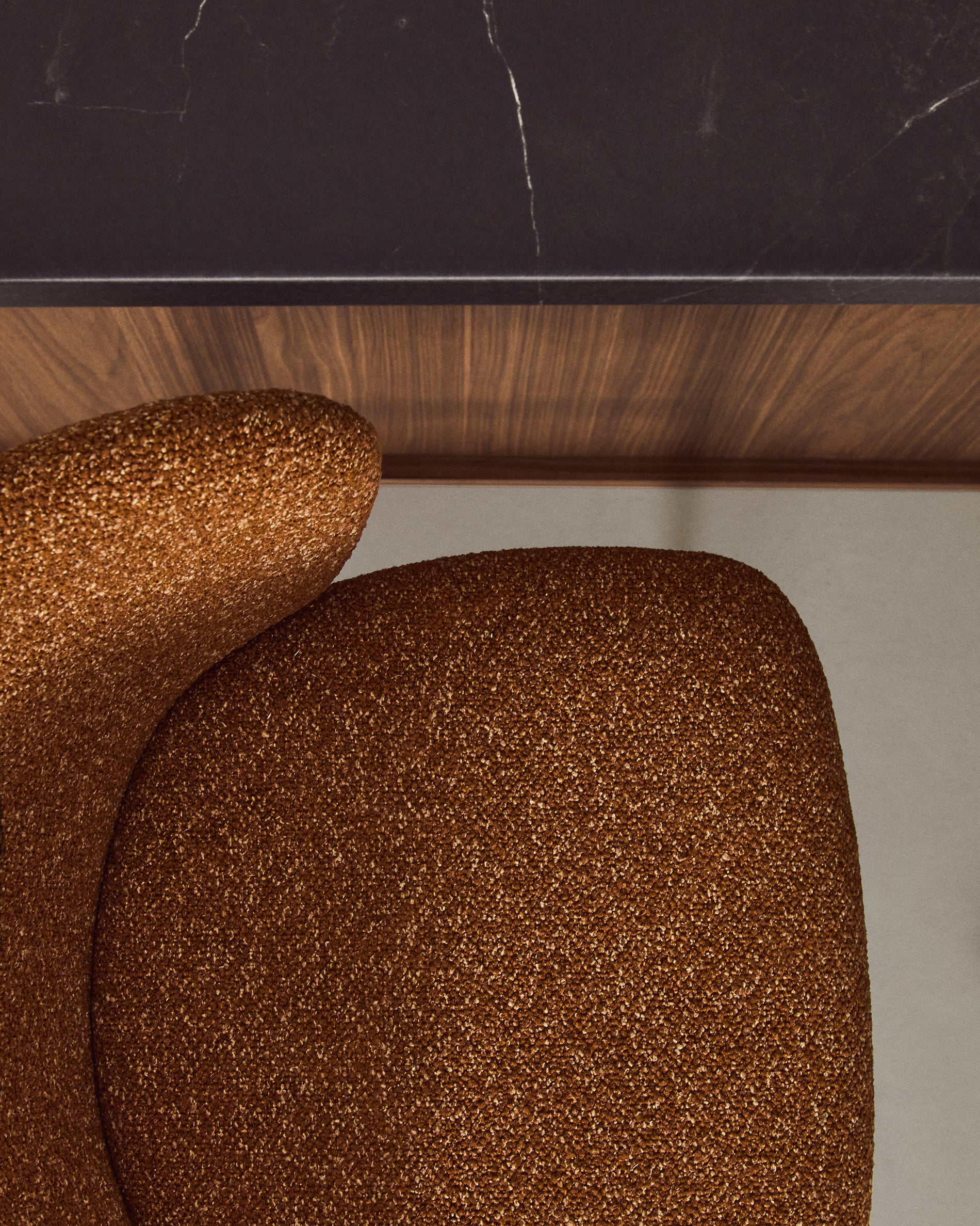 Stylischer Hocker Ciselia aus weichem, terrakottafarbenem Chenille, ausgestattet mit stabilen, schwarzen Stahlbeinen – perfekt für moderne Wohnräume.