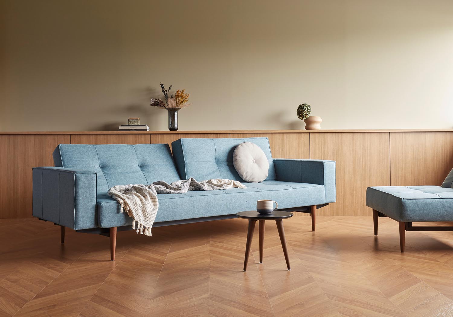 Elegantes Splitback Sofabett 115 Styletto mit Armlehnen, ideal für stilvolle Wohnräume und flexible Nutzung als Sofa oder Bett.