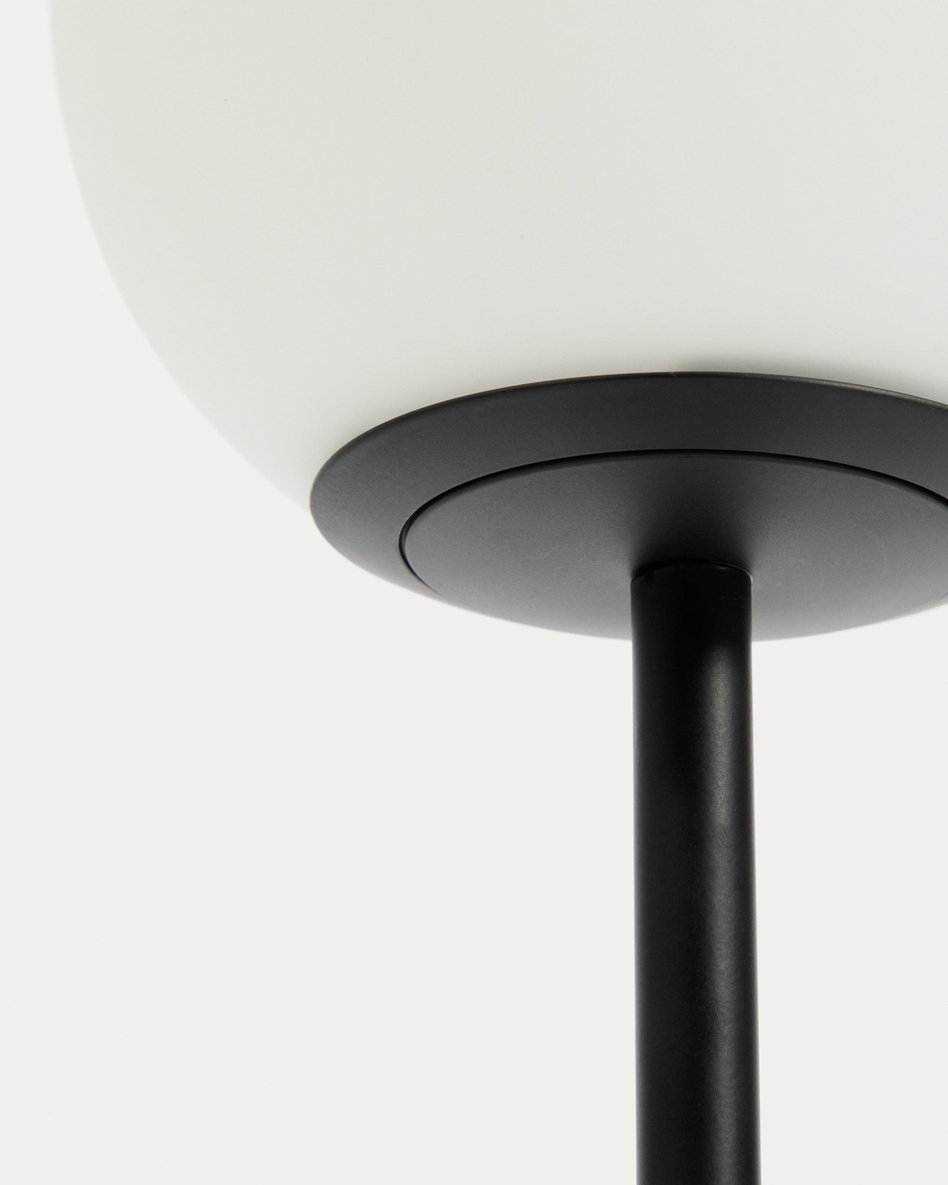 Elegante Tischlampe Brisia aus robustem Metall in Schwarz, ausgestattet mit einer dekorativen Glaskugel, ideal für ein modernes Ambiente.