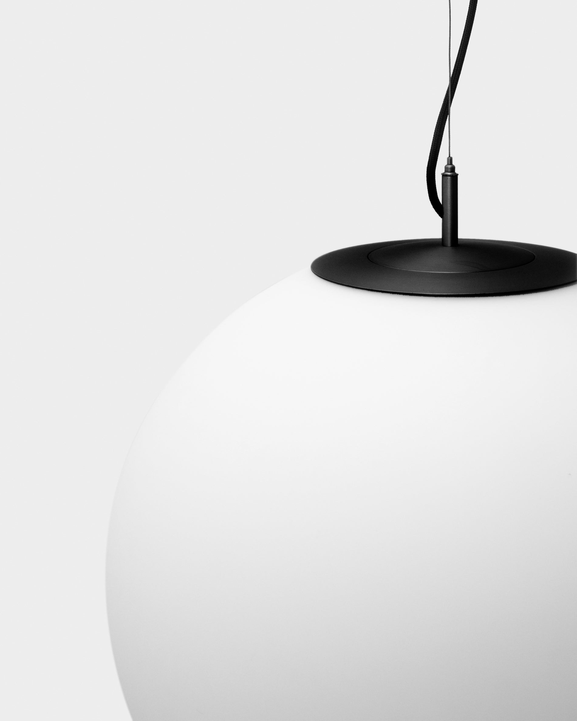 Moderne Deckenleuchte Brisia aus robustem Metall in Schwarz, ausgestattet mit einer eleganten Glaskugel, ideal für stilvolle Innenräume.