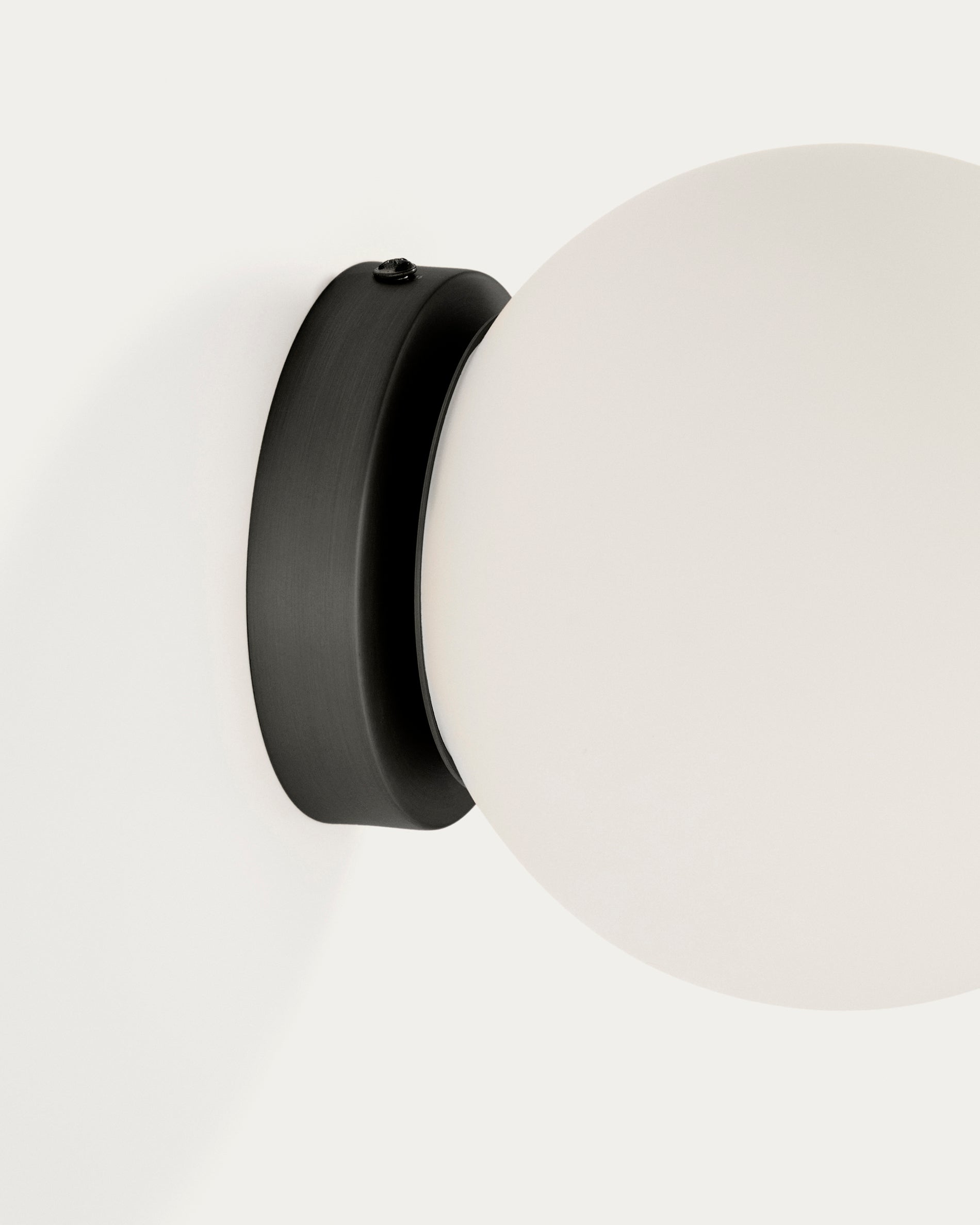 Elegante Wandleuchte Brisia aus schwarzem Metall mit einer 15 cm großen Glaskugel, ideal für eine stilvolle Raumgestaltung.