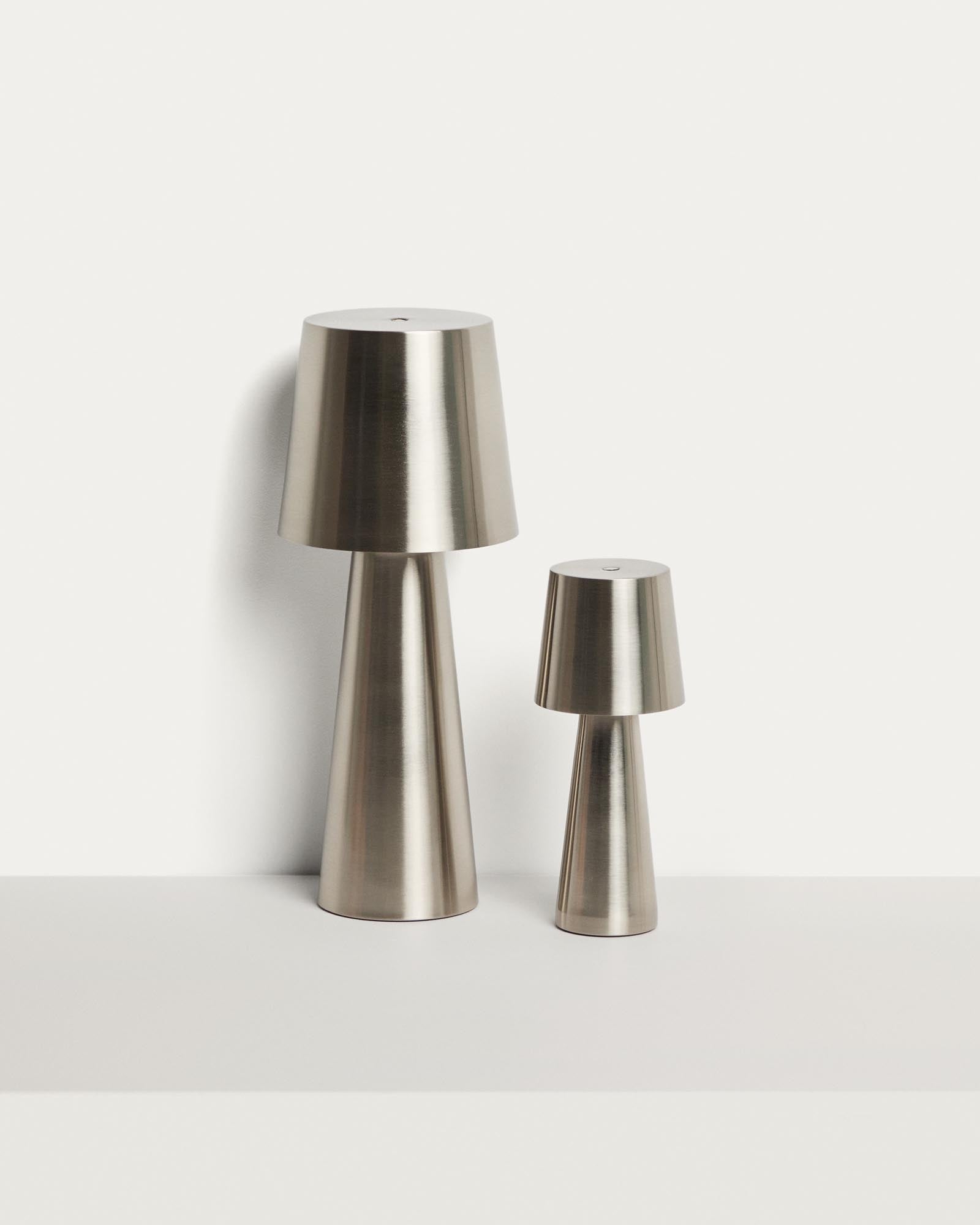 Kleine, stilvolle Tischlampe Arenys aus Metall mit silbernem Glanz, perfekt für gemütliche Abende im Freien auf Balkon oder Terrasse.