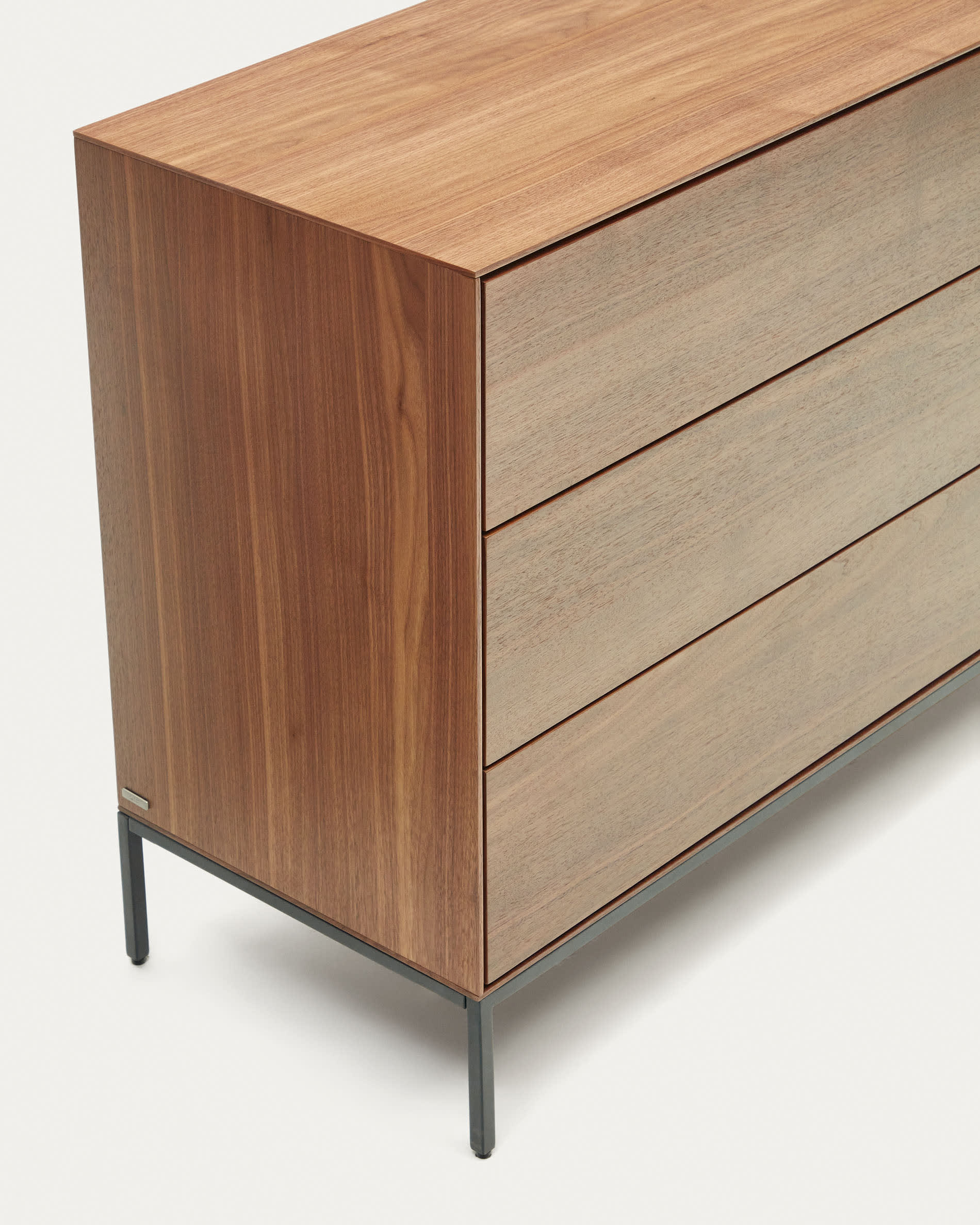 Die Vedrana Kommode vereint elegantes Nussholzfurnier mit stabilen Stahlbeinen und bietet praktischen Stauraum in modernem Design.