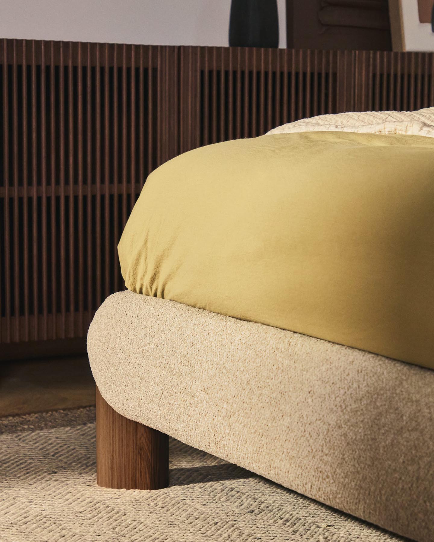 Elegantes Bett Odina in edlem Ecru, gefertigt aus weichem Boucléstoff und stabilen Eschenbeinen, ideal für zeitgemäße Schlafzimmer.