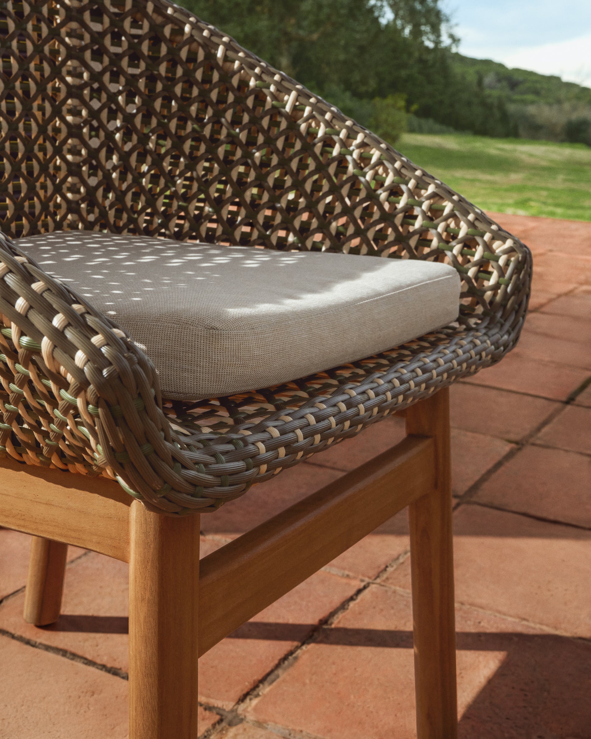 Eleganter Gartenstuhl Olbia aus robustem Teakholz und pflegeleichtem synthetischem Rattan in Dunkelgrün, ideal für entspannte Stunden im Freien.