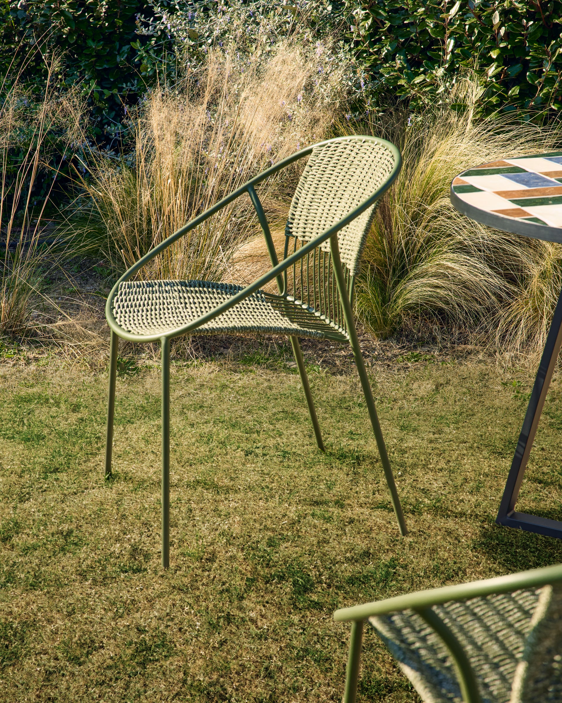 Stapelbarer Gartenstuhl Atrani in modernem Design, gefertigt aus langlebigem verzinktem Stahl und grünem Seil, perfekt für Terrasse und Garten.