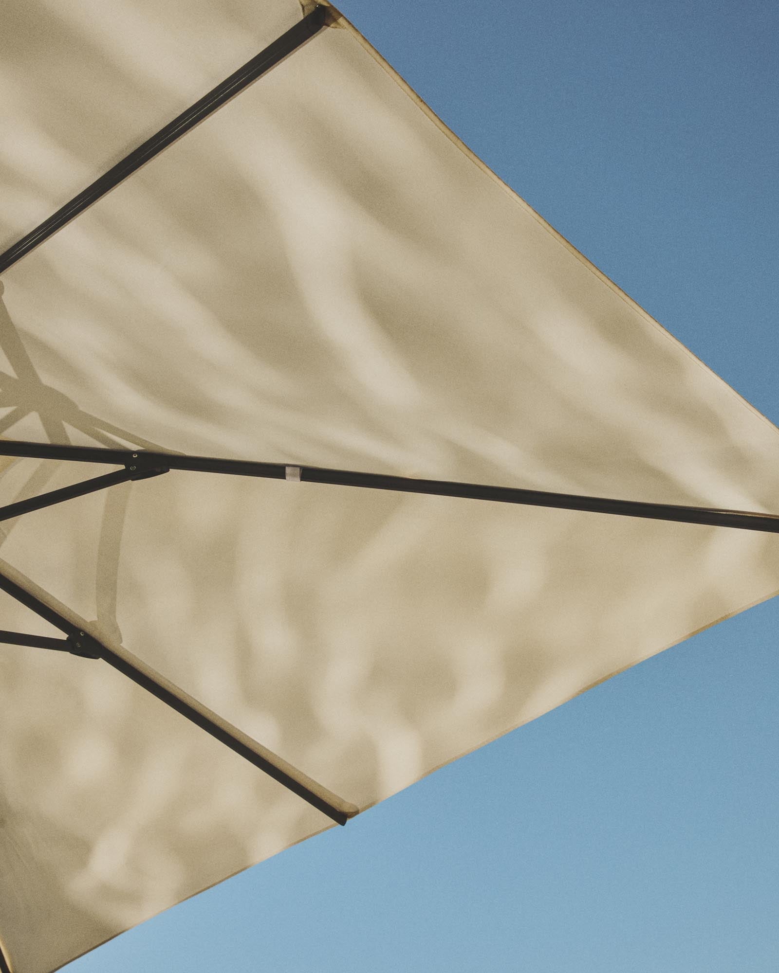 Eleganter Sonnenschirm Noli in Beige, mit robustem graphitgrauem Aluminiumgestell, perfekt für schattige Oasen im Freien.