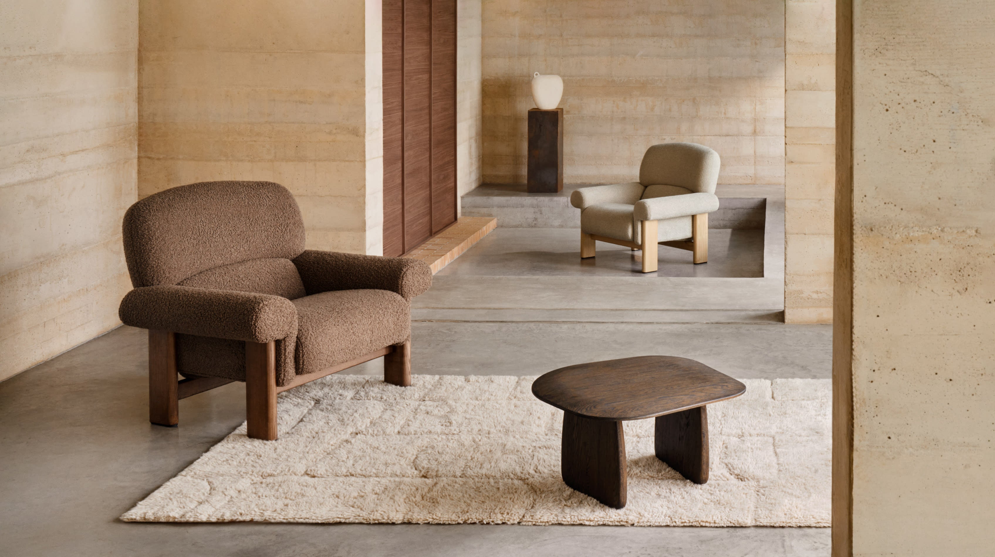 Eleganter Sessel Nema aus taupefarbenem Bouclé und FSC-zertifiziertem Eschenholz mit natürlichem Finish, perfekt für stilvolles Wohnen.