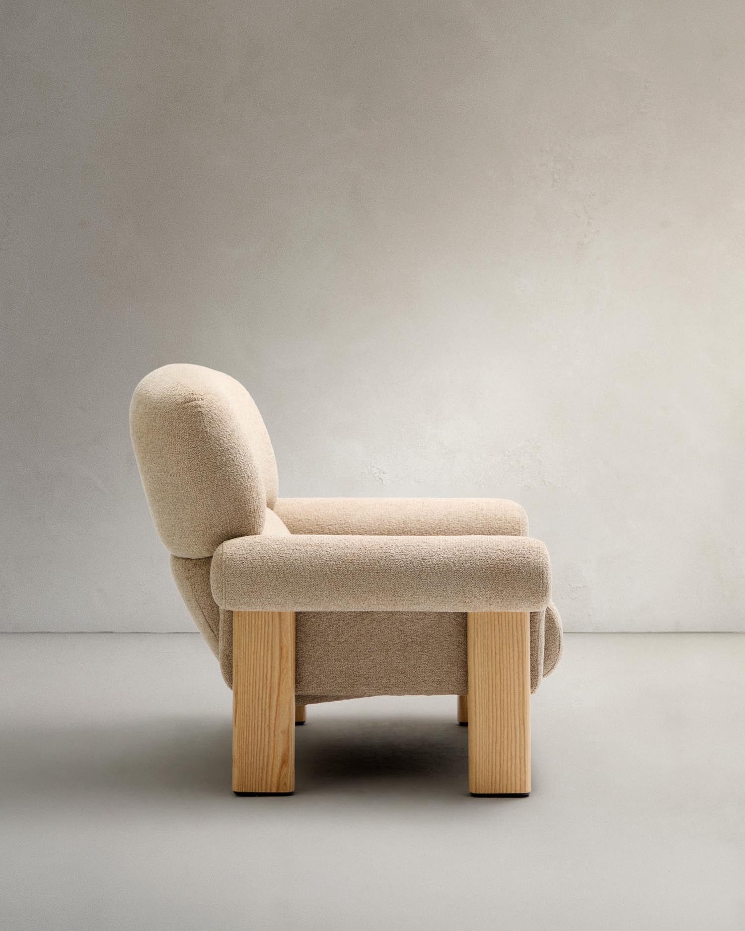 Beiger Chenille-Sessel Nema mit stabilen Eschenholzbeinen, perfektes Möbelstück für stilvolle Wohnräume und gemütliche Atmosphäre.