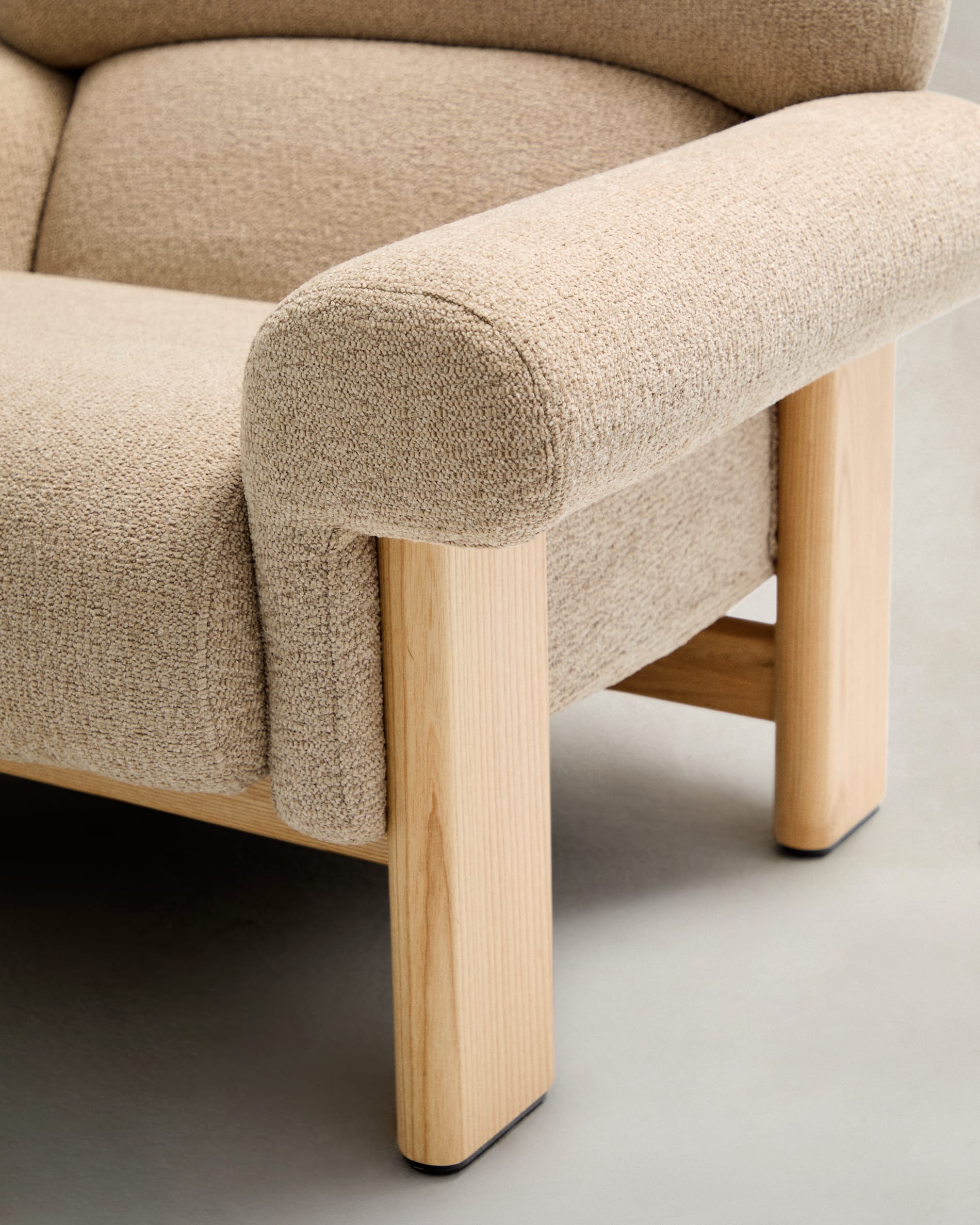 Sessel Nema: Eleganz und Nachhaltigkeit vereint. Beigefarbener Chenille-Bezug und massives Eschenholz schaffen ein stilvolles Ambiente.