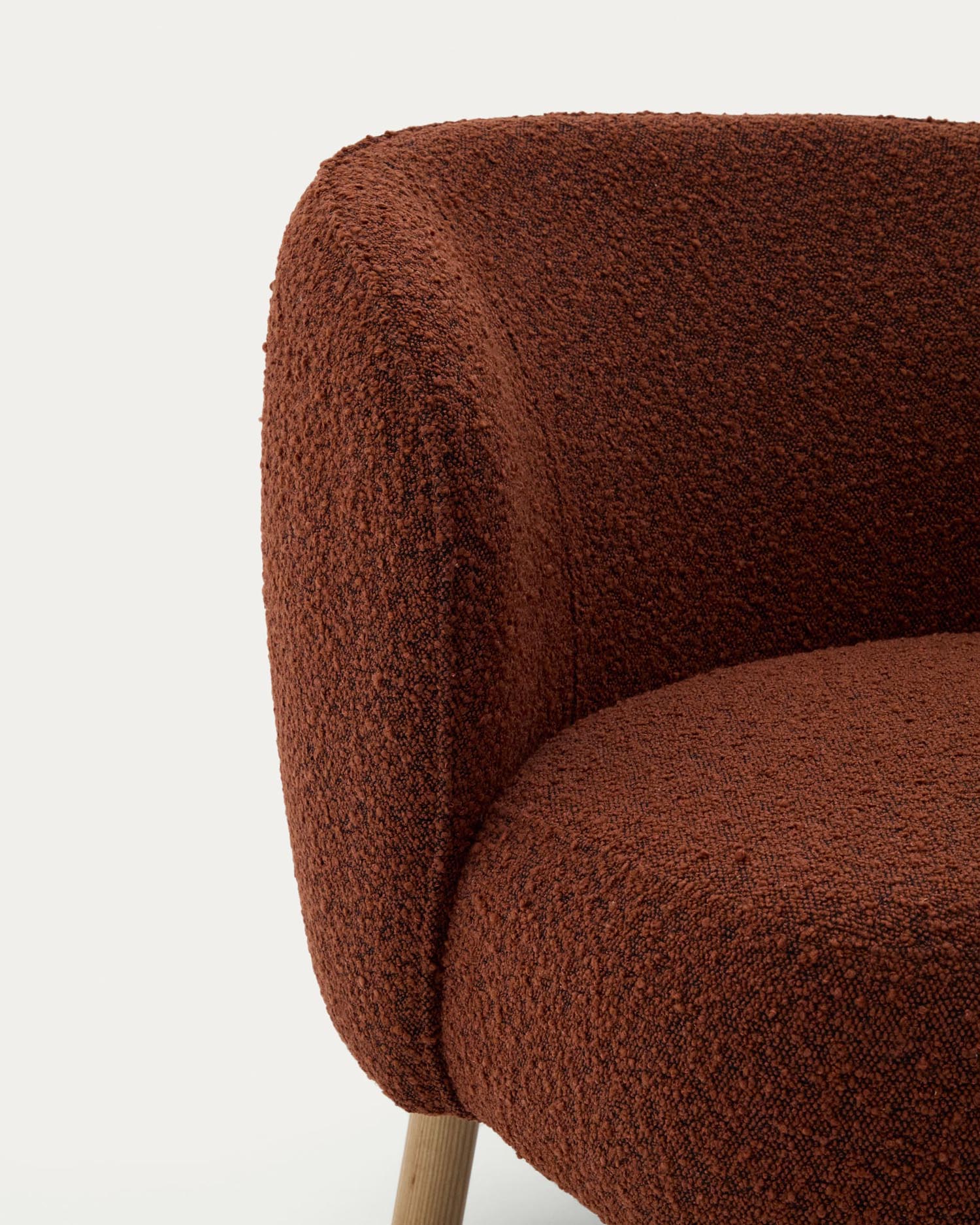 Sessel Ulit: Eleganter Sessel mit weichem terrakottafarbenem Schaffell und robusten Buchenholzbeinen, perfekt für stilvolle Entspannung in jedem Raum.