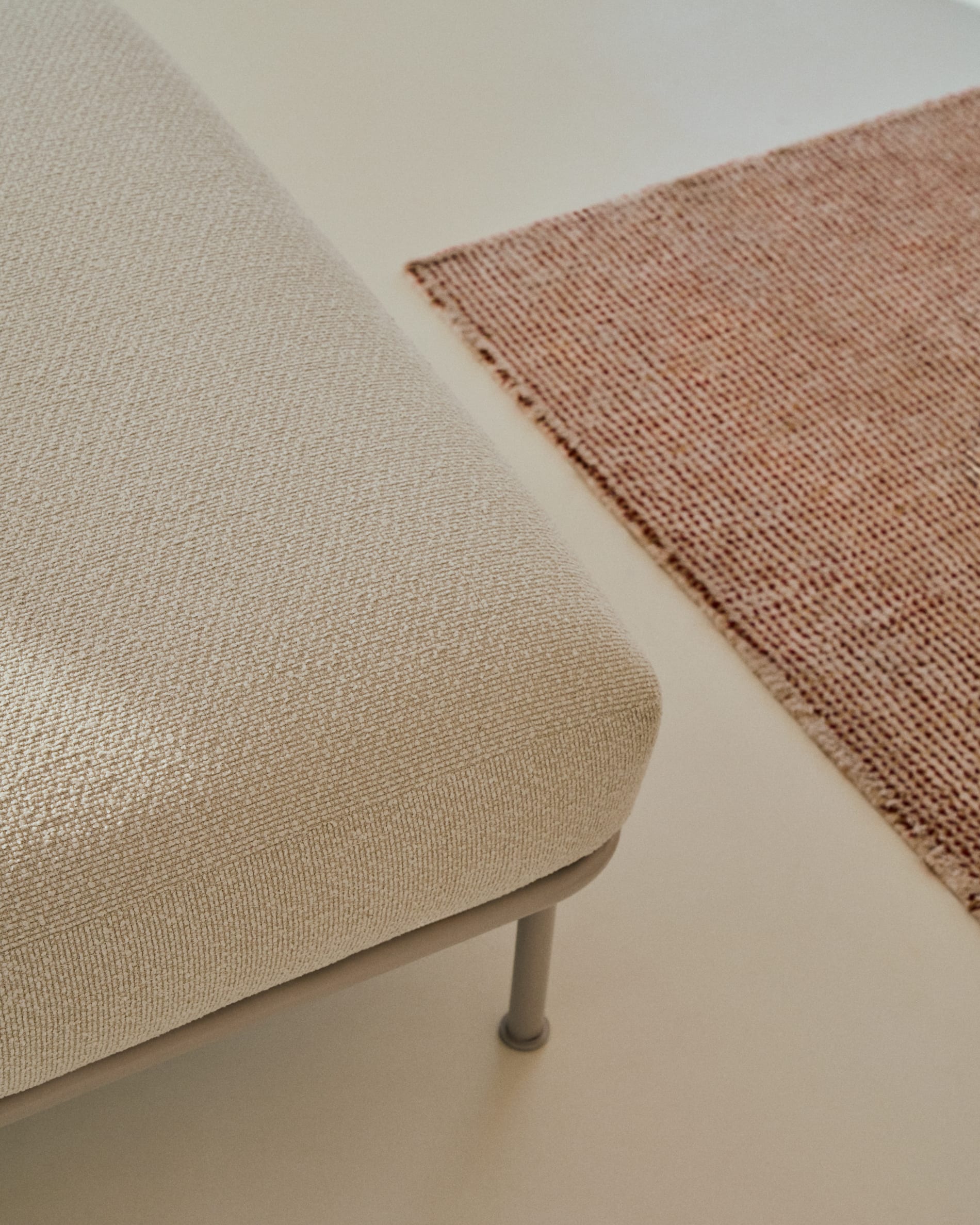 Elegante Fussablage Aurum in sanftem Ecru, 85 x 85 cm, aus hochwertigem Chenille und robuster Metallbasis – perfekt für jedes stilvolle Zuhause.