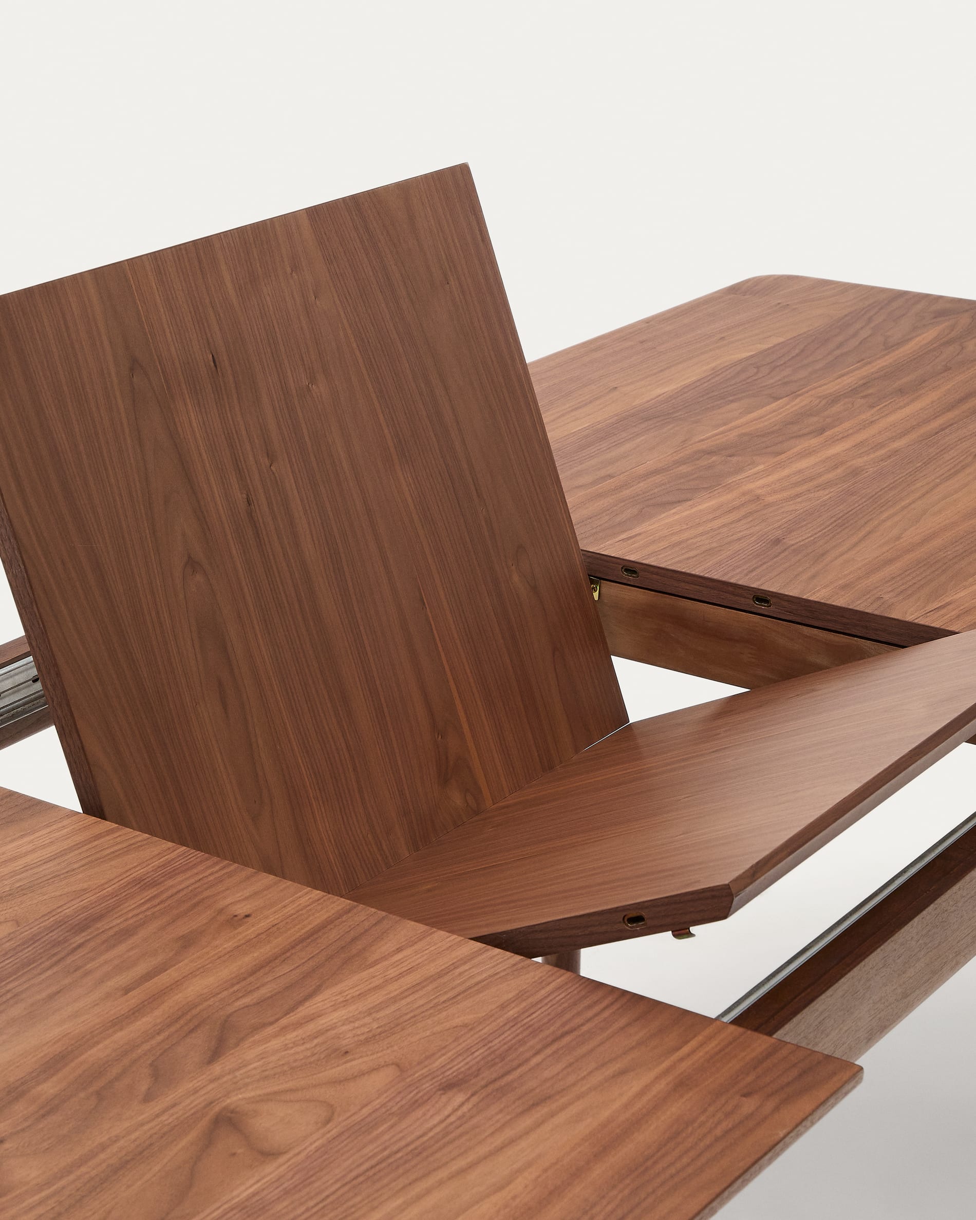 Erleben Sie den ausziehbaren Tisch Elan von Kave Home: Massives Nussbaumholz, elegante Optik und flexibles Design für gesellige Anlässe.