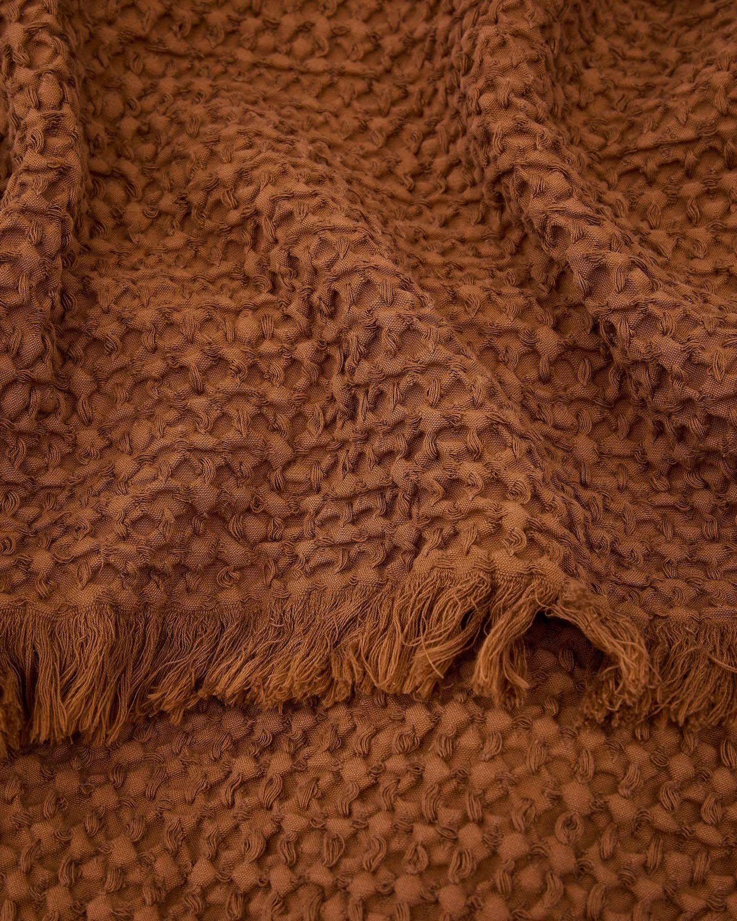 Gemütliche Nulina Wolldecke in dunkelorange, gefertigt aus 100% Baumwoll-Waffelpiqué. Ideal für stilvolle Akzente in jedem Raum. Maße: 130 x 170 cm.