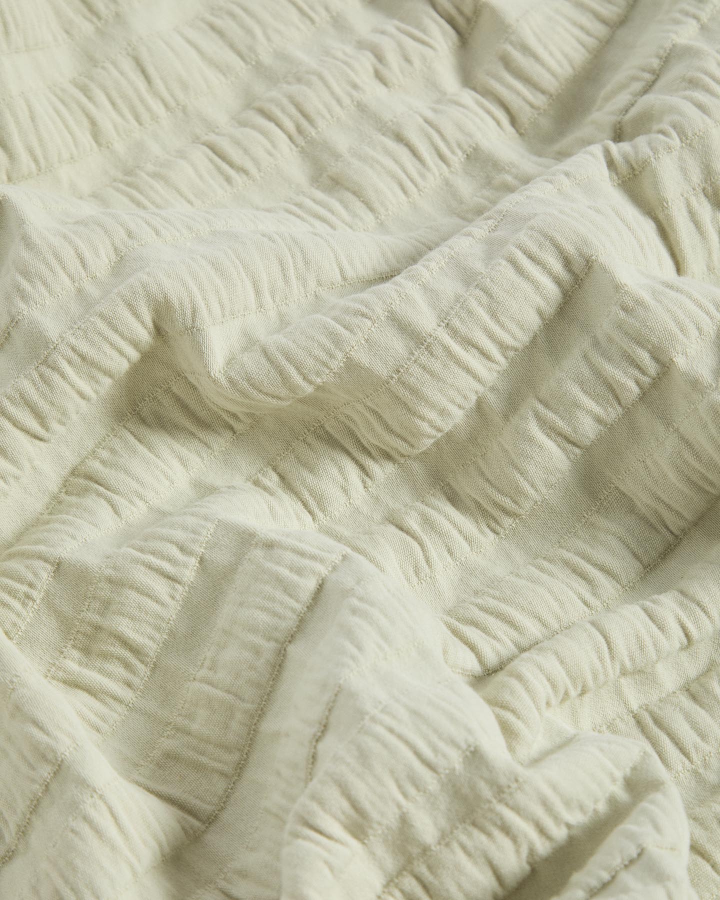 Helle Baumwoll-Tagesdecke Rilune mit Reliefstreifen in sanftem Grün, ideal für die gemütliche Gestaltung von Babybetten.